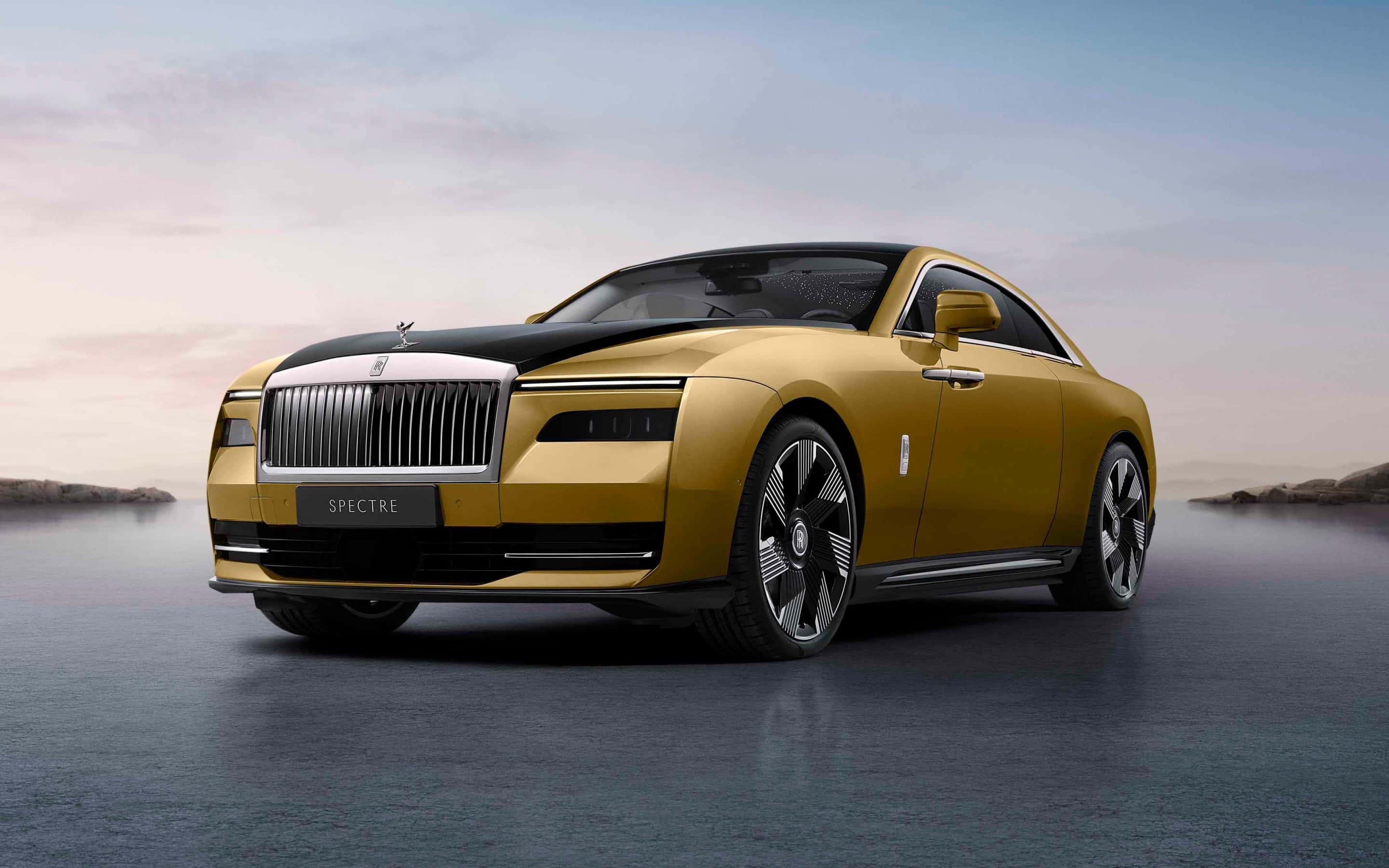 Gold Cars 桌布 壁紙 — 一輛豪華金色勞斯萊斯 Spectre 轎跑車在潮濕的反光表面上閃耀，背景是柔和的暮色天空。