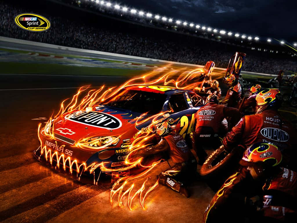nascar 桌布 壁紙 — 一輛車身噴出火焰的火熱NASCAR賽車，在夜間明亮的體育場燈光下由工作人員進行維修。