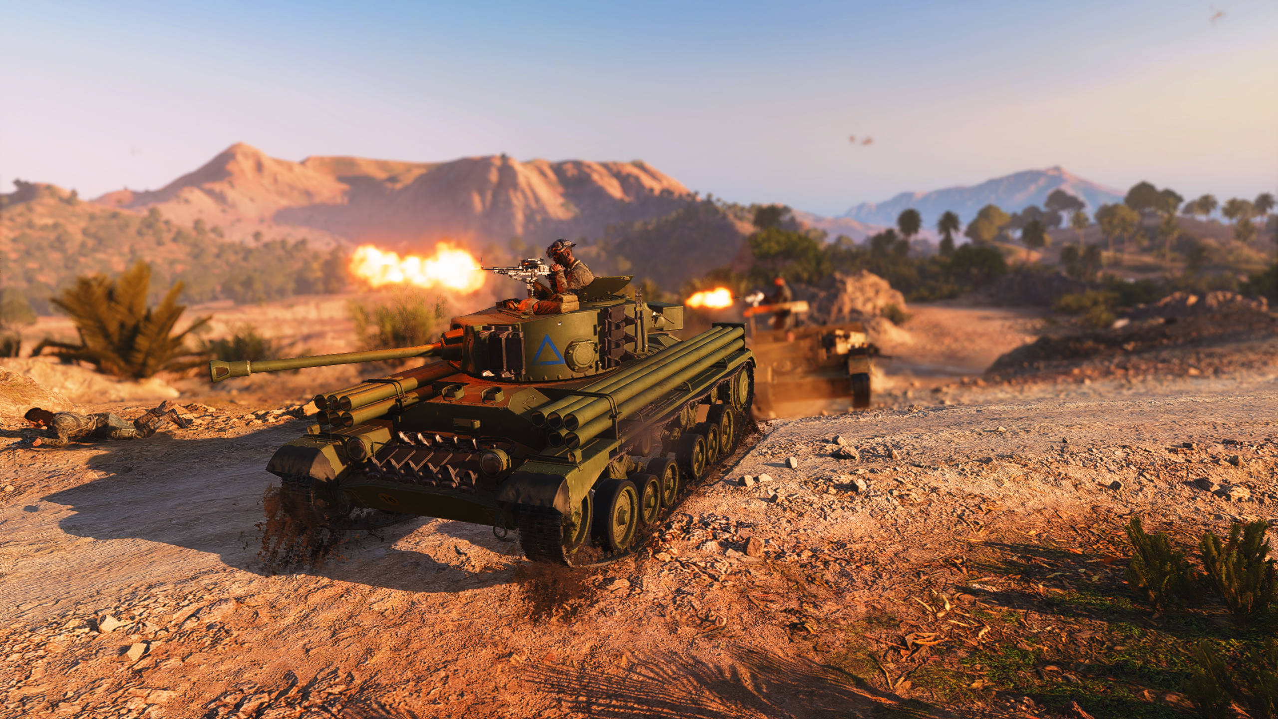 Battlefield 5 桌布 壁紙 — 一輛軍用坦克在沙漠戰場上開火，爆炸和遠山在金色日落之下。