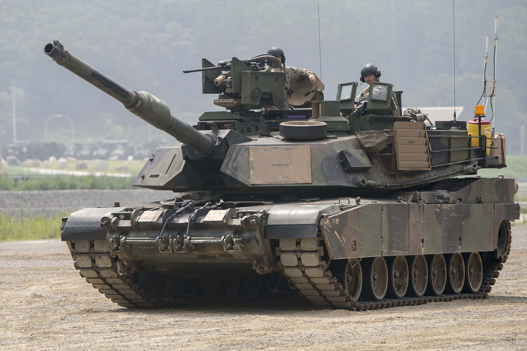 坦克 桌布 壁紙 — 一輛載有士兵的軍用坦克停在塵土飛揚的田野上，背景有山丘。