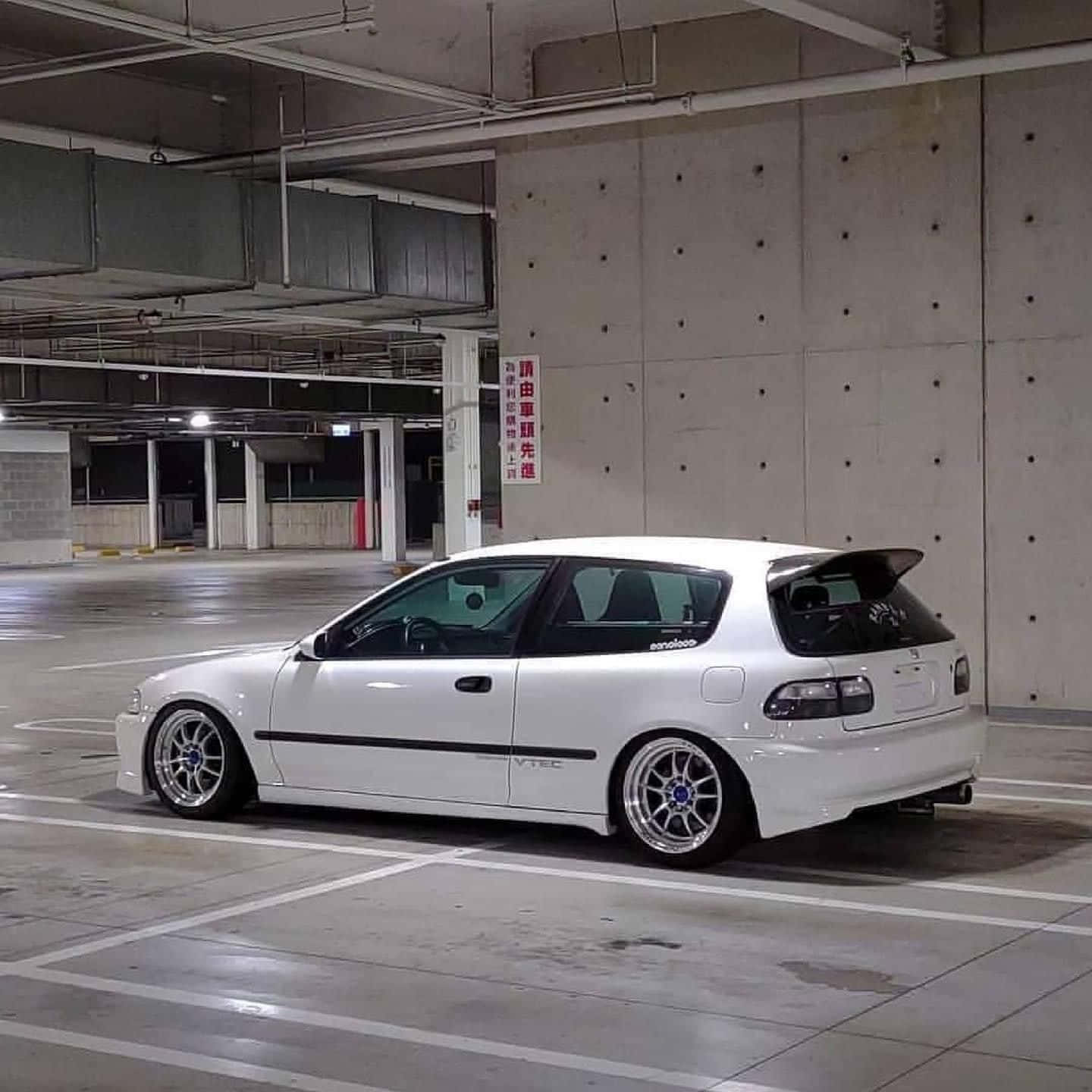 Hatchback 桌布 壁紙 — 一輛配備訂製輪圈的時尚白色本田思域，獨自停放在燈光昏暗的地下停車場。