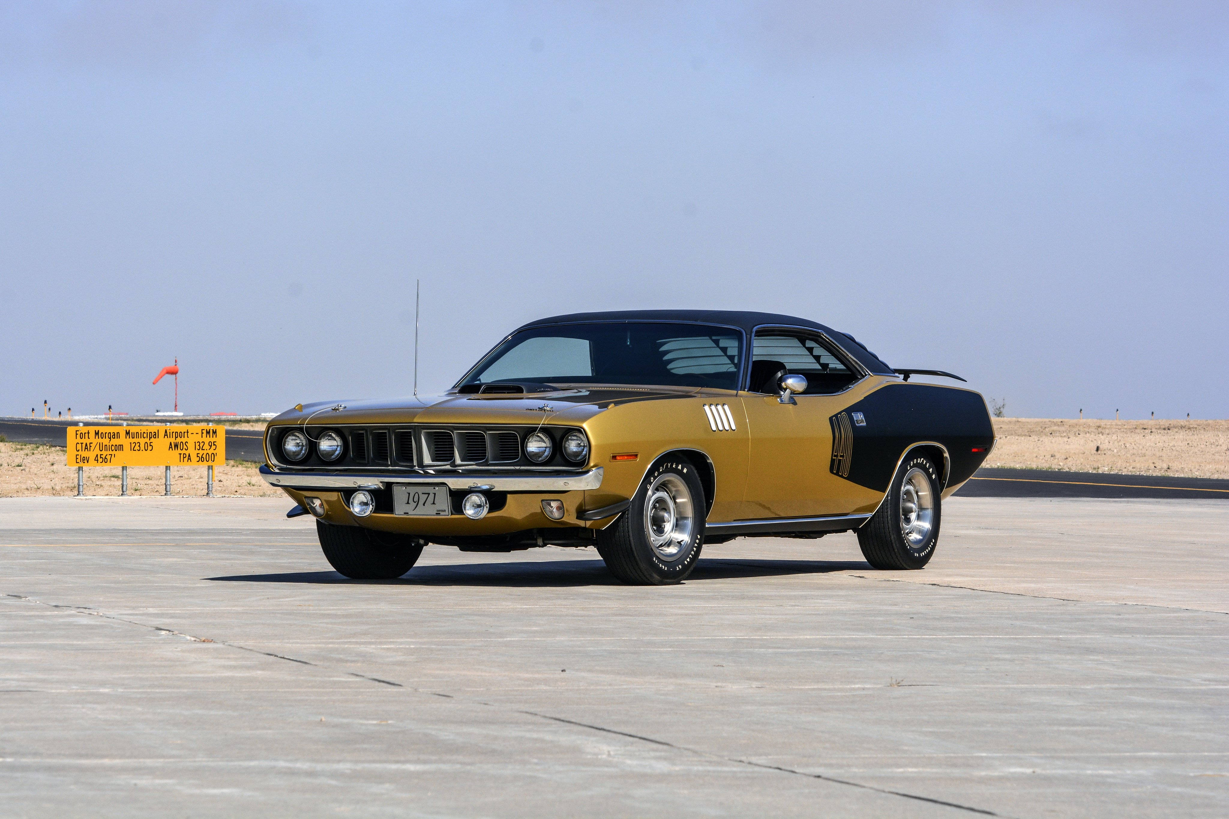 Barracuda 桌布 壁紙 — 一輛金色和黑色的1971年Plymouth肌肉車停在沙漠停機坪上，天空湛藍清澈。