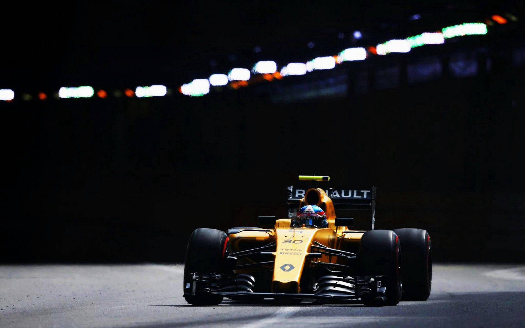 Renault 桌布 壁紙 — 一輛金色的雷諾一級方程式賽車在夜間賽道上奔馳，賽道被模糊的邊燈照亮。