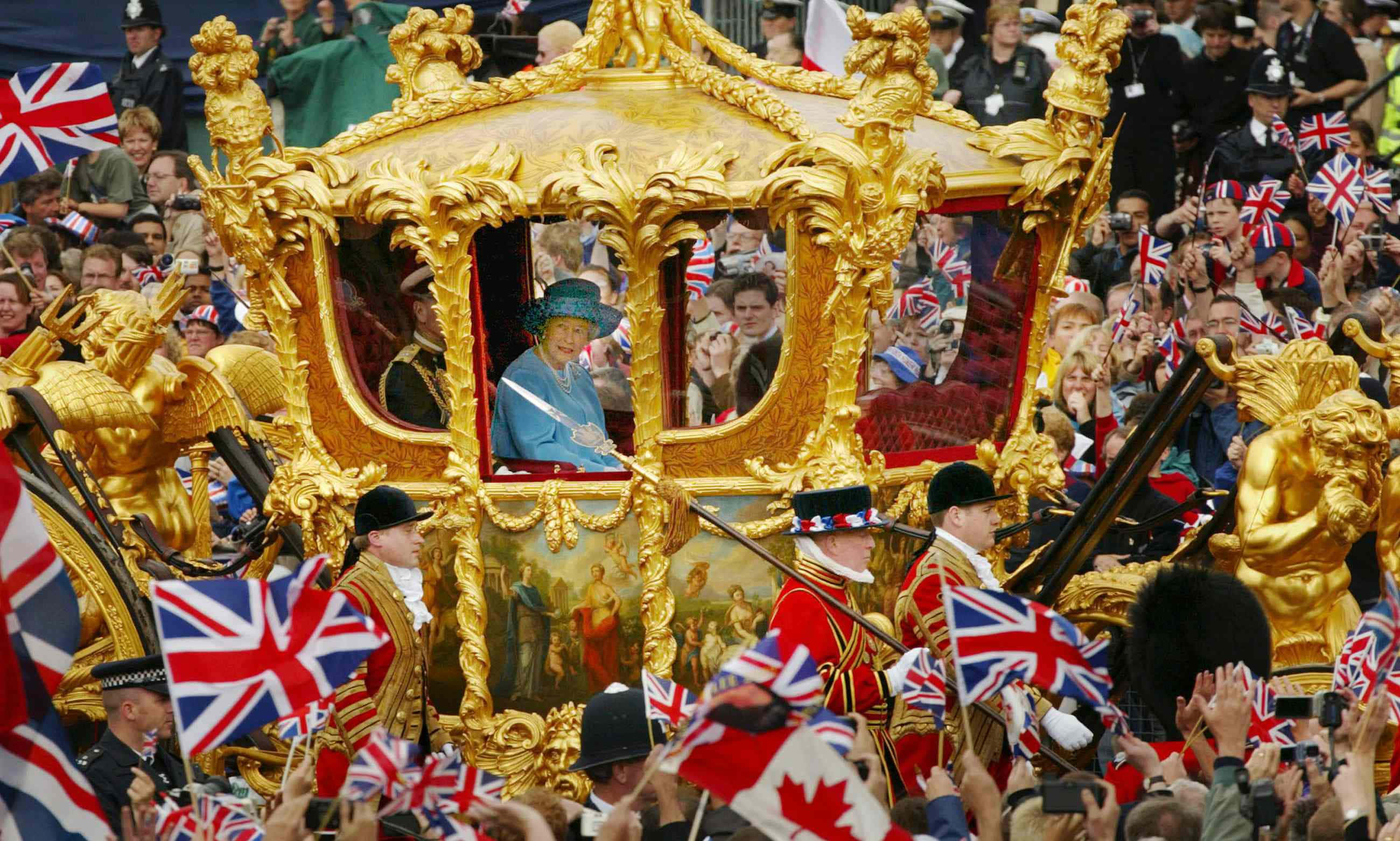 Queen Elizabeth 桌布 壁紙 — 一輛金色皇家馬車，伊麗莎白二世女王在車內揮手，周圍是公眾遊行中揮舞英國國旗的人群。