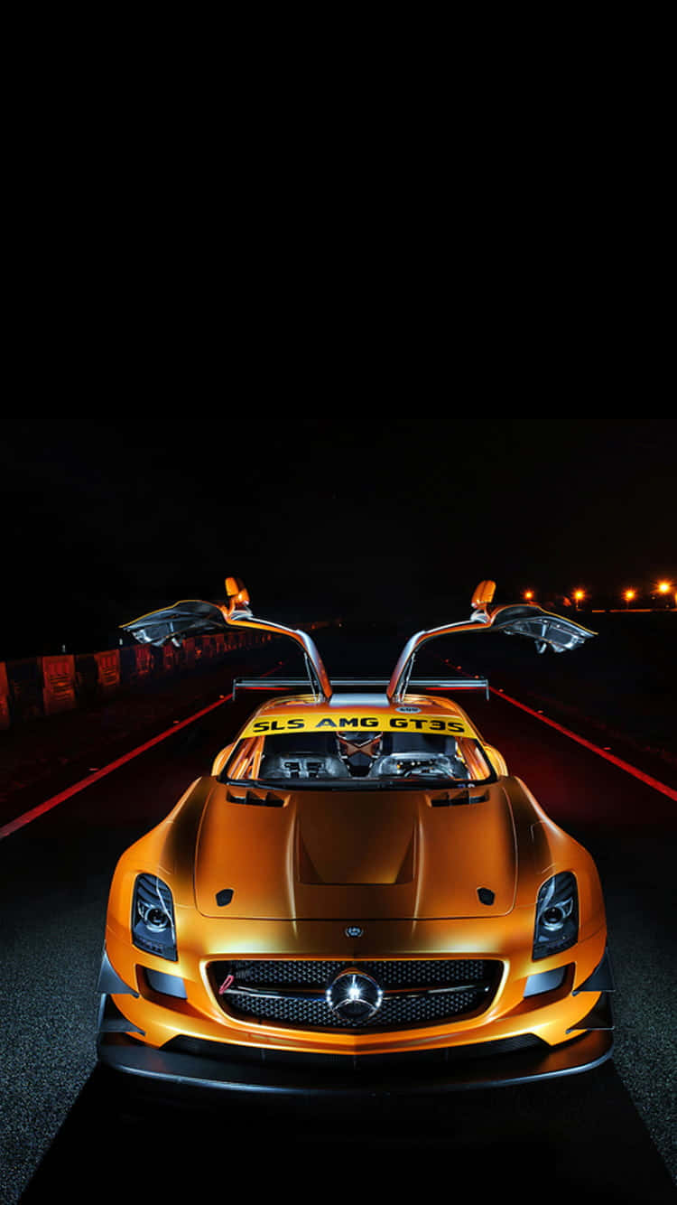 手機鎖定螢幕 桌布 壁紙 — 一輛金色賓士 SLS AMG GT3 賽車，在夜間黑暗賽道上，車燈下打開鷗翼車門。