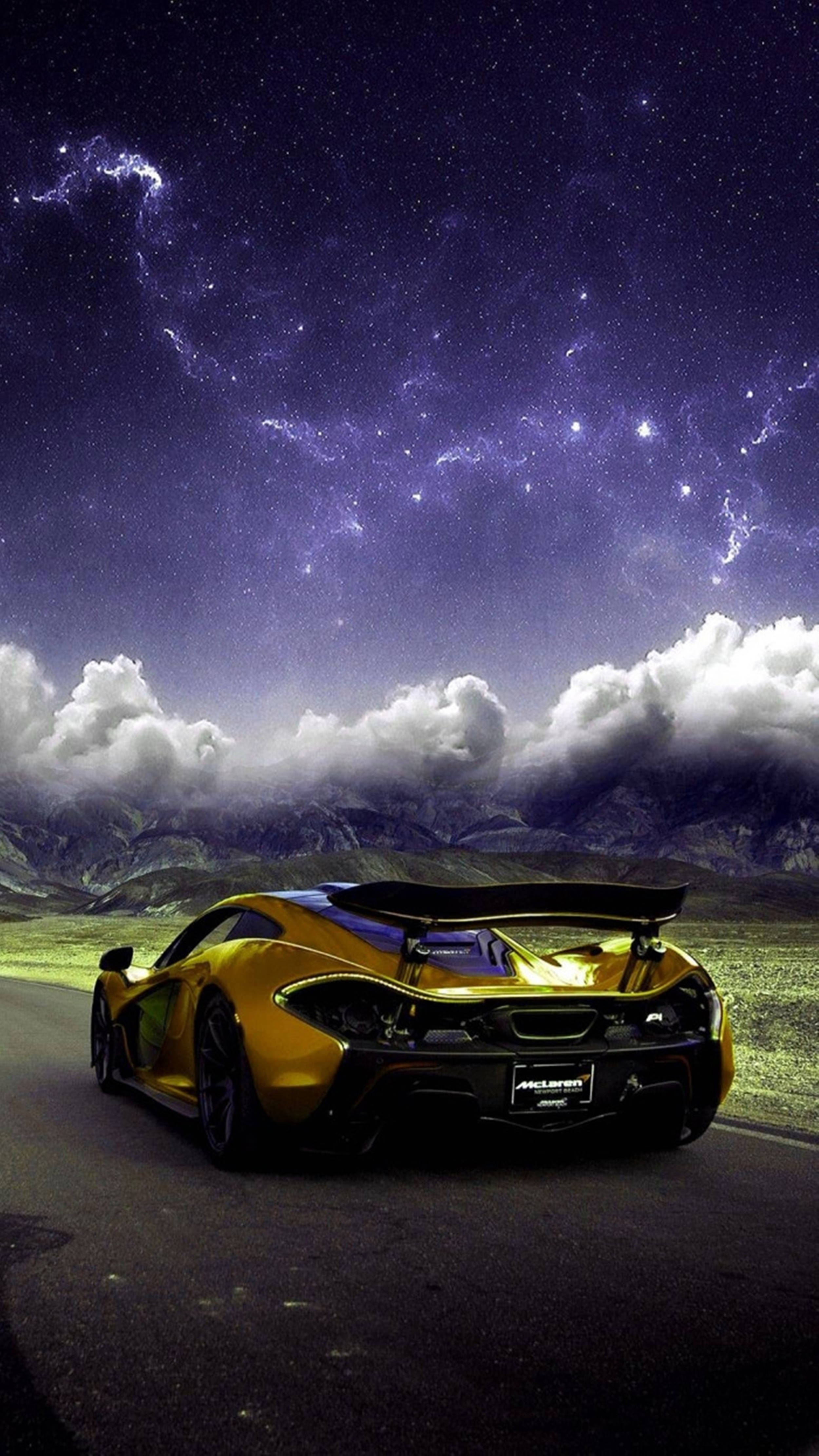 雲朵 桌布 壁紙 — 一輛金色跑車停泊在道路上，上方是充滿活力的紫色星空，伴有戲劇性的雲層和遠山。