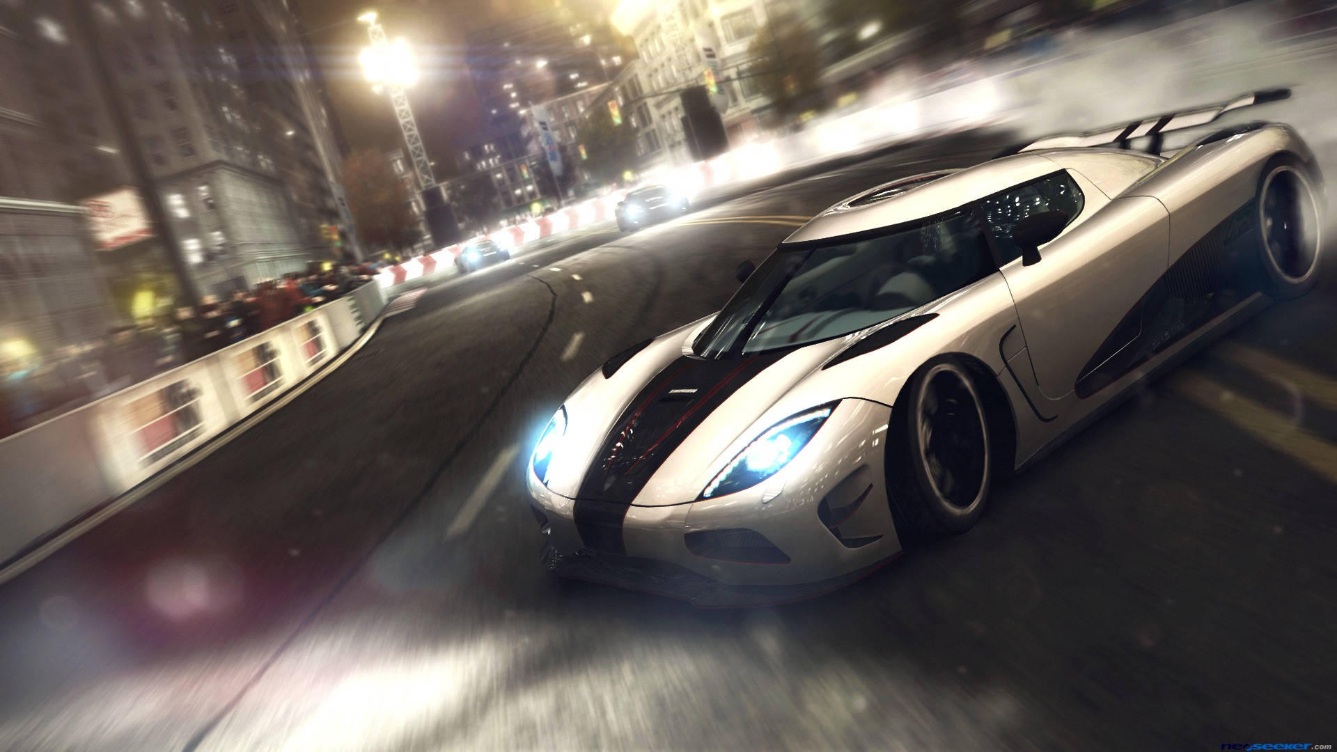 grid 桌布 壁紙 — 一輛銀色 Koenigsegg 超級跑車在夜間穿過霓虹燈閃爍的城市街道，帶有動態模糊和發光的車頭燈。