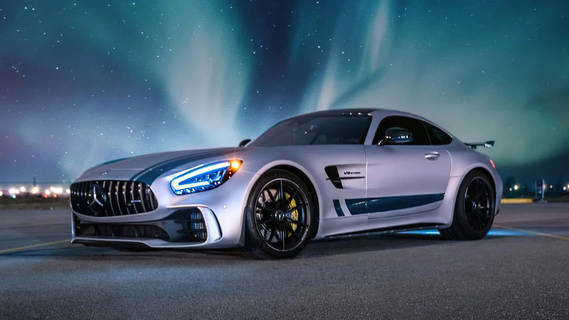 Classic Mercedes 桌布 壁紙 — 一輛銀色 Mercedes-AMG GT Black Series 跑車在夜間充滿活力的綠色北極光下閃耀。