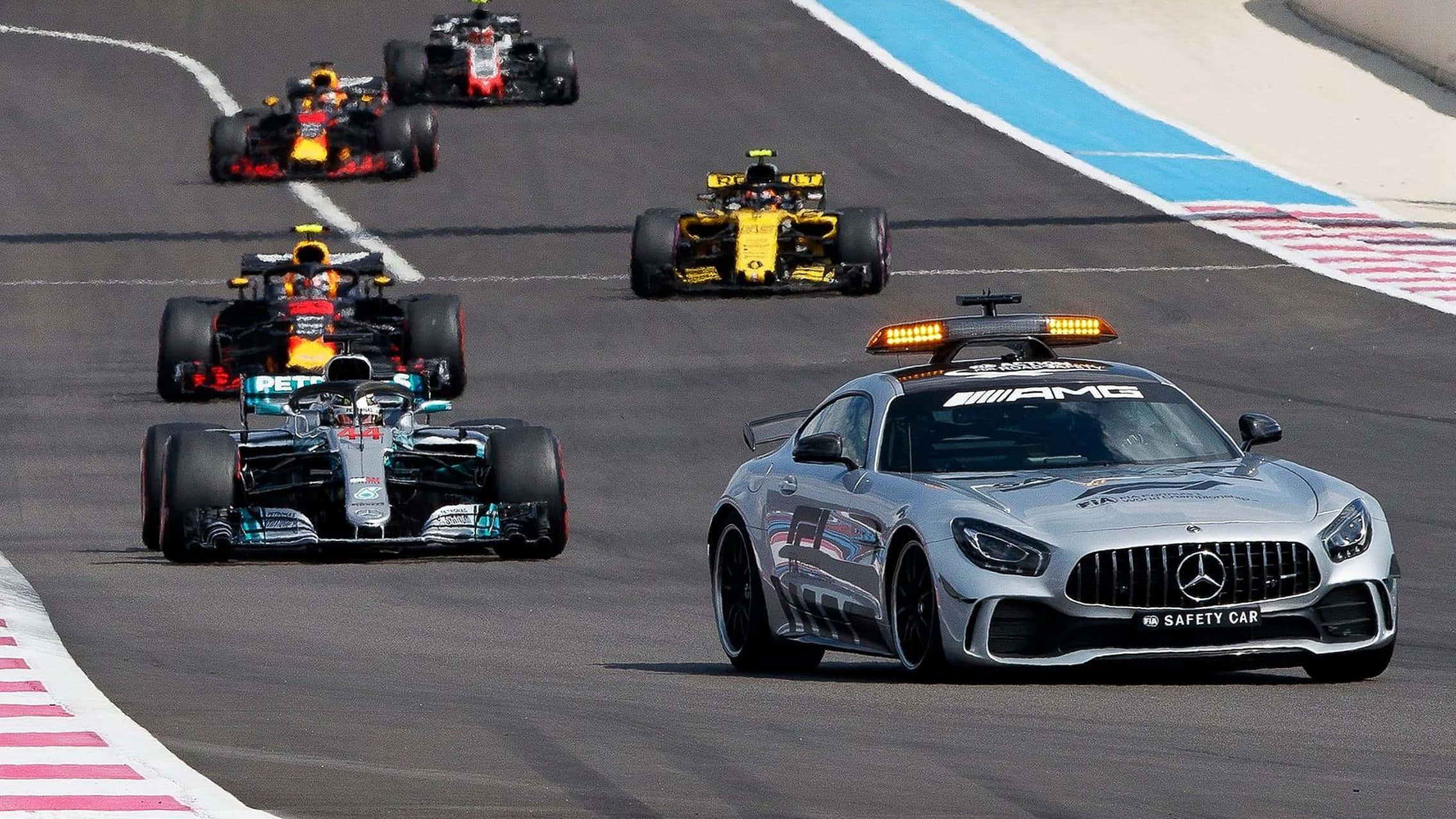 HD F1 2016 桌布 壁紙 — 一輛銀色 Mercedes-AMG 安全車帶領著一隊色彩繽紛的 Formula 1 賽車在陽光明媚的賽道上行駛。