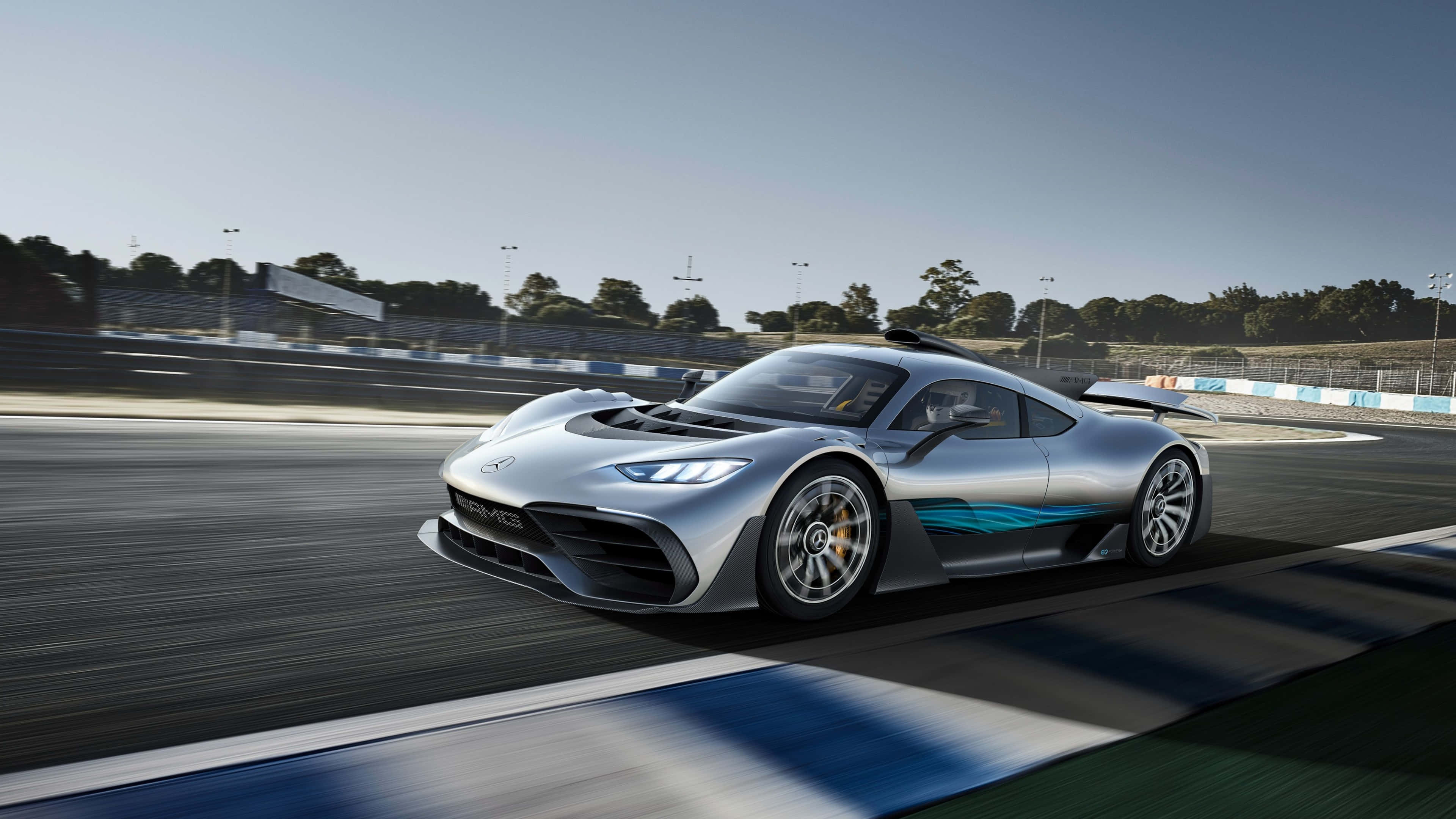 電玩遊戲 桌布 壁紙 — 一輛銀色 Mercedes-AMG One 超級跑車在明亮的日光下，伴隨動態模糊沿著賽道飛馳。