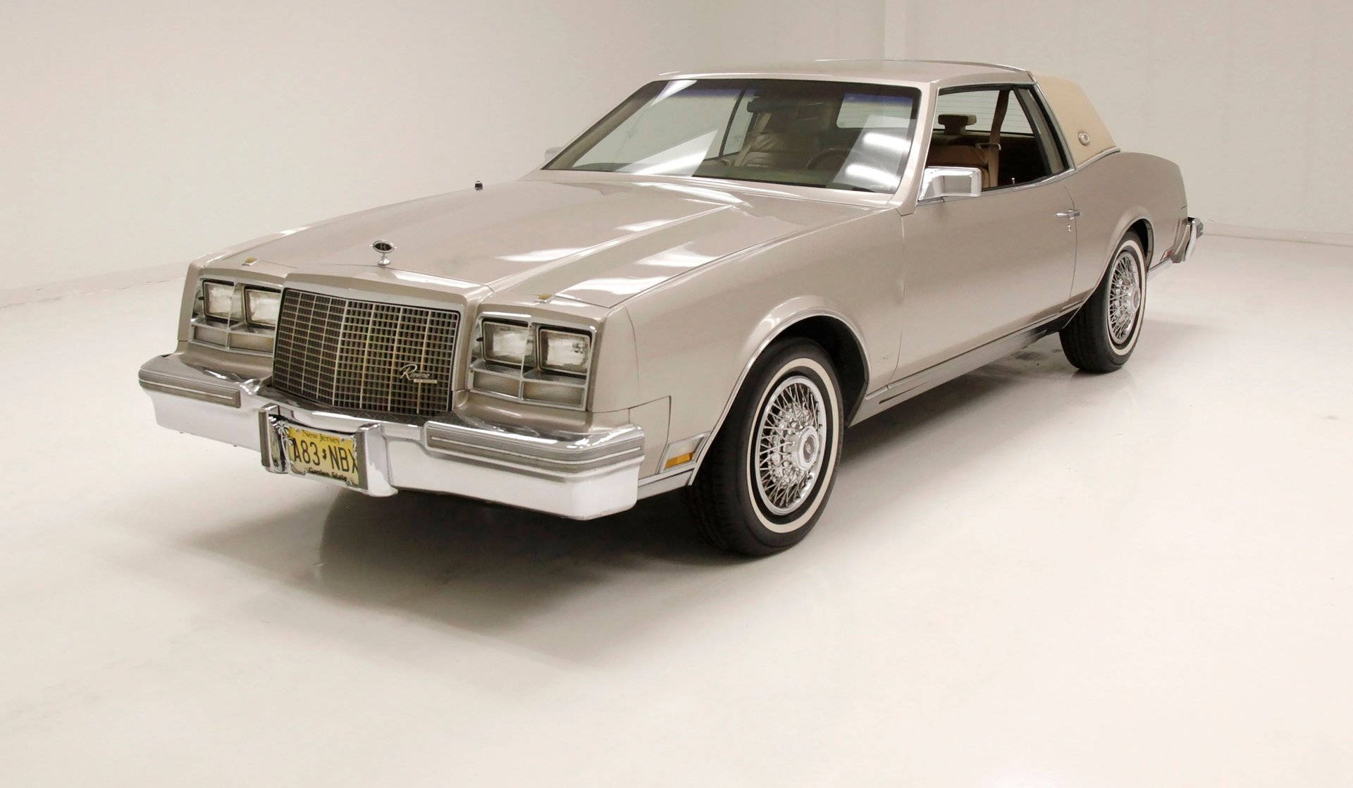 Buick 桌布 壁紙 — 一輛銀色1980年代凱迪拉克雙門轎車，帶有鍍鉻裝飾和白牆輪胎，在明亮的白色工作室中展示。