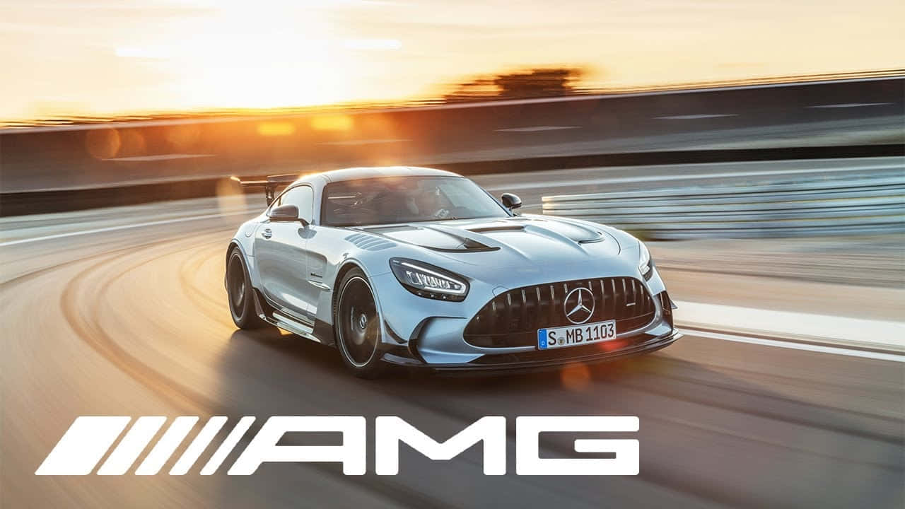 Mercedes Gts 桌布 壁紙 — 一輛銀色AMG跑車在日落時分沿著賽道飛馳，帶有動態模糊和閃爍的車頭燈。