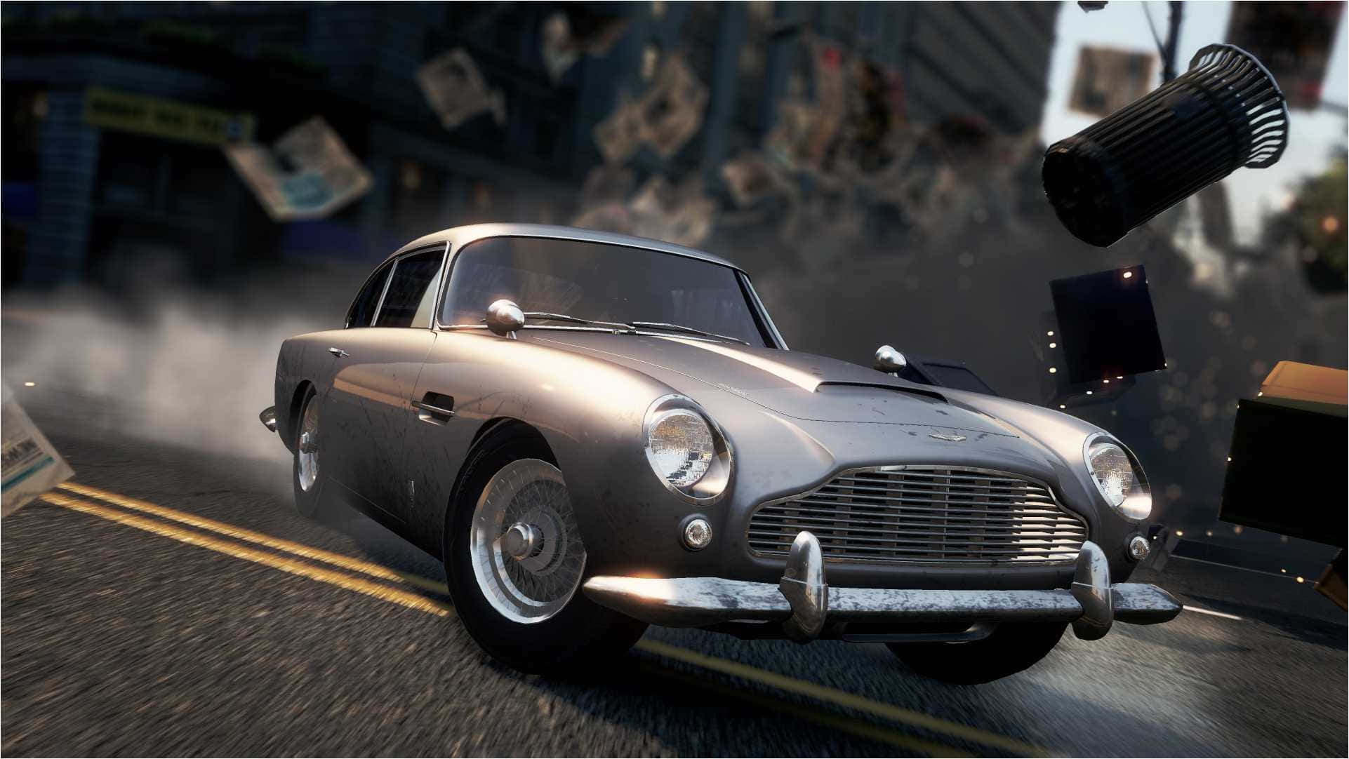 Aston Martin Db5 桌布 壁紙 — 一輛銀色Aston Martin DB5在混亂的城市街道上飛馳，碎片飛揚，輪胎周圍煙霧瀰漫。