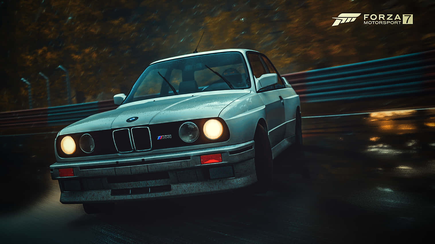 跑車 桌布 壁紙 — 一輛銀色BMW M3在雨濕的夜間賽道上飛馳，發光的車頭燈劃過因動態模糊的秋樹。