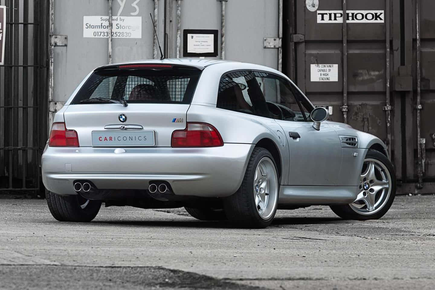 Bmw Z3 桌布 壁紙 — 一輛銀色BMW Z3 M Coupe停放在工業儲存設施，可見排氣管和合金輪圈。