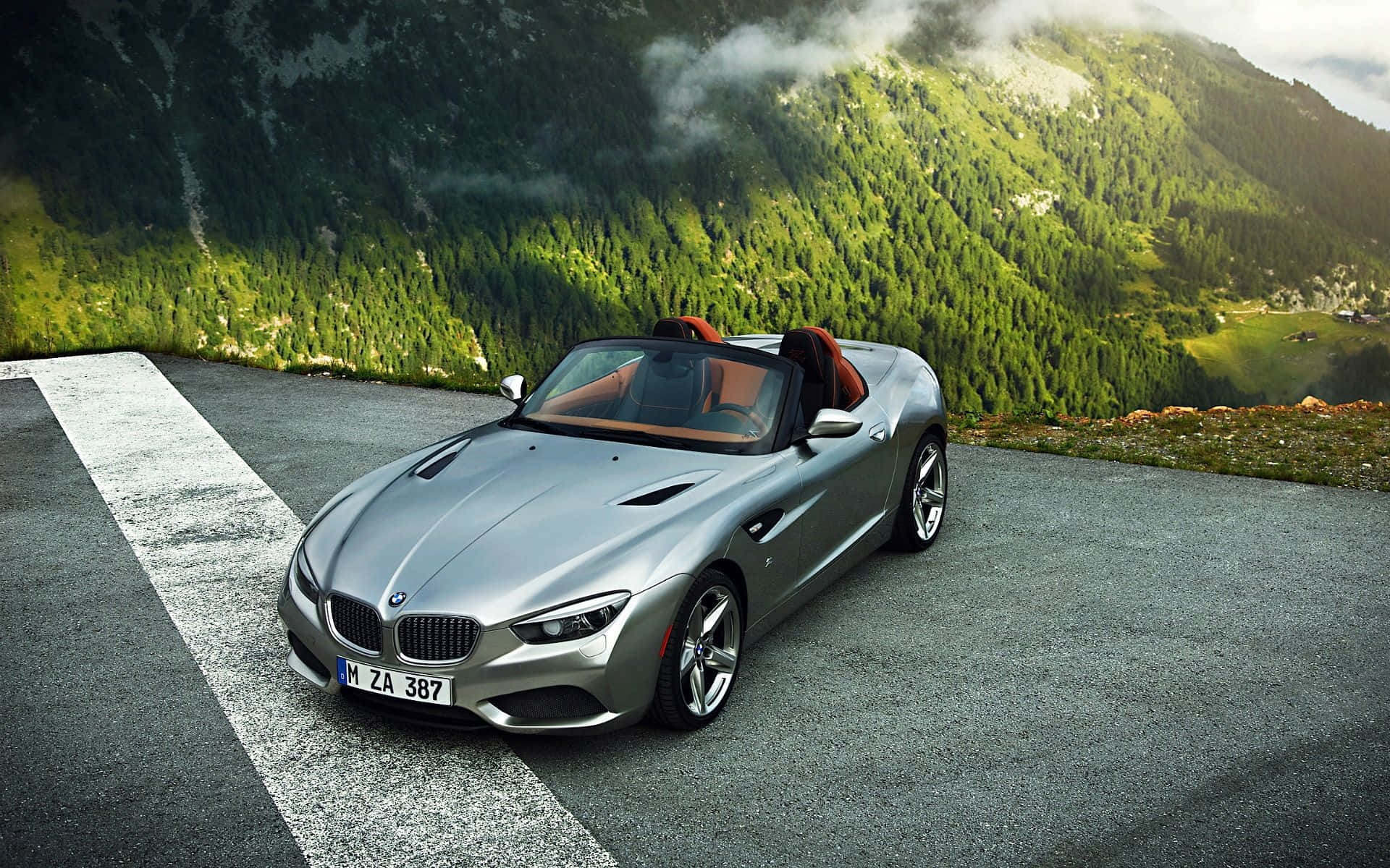 Bmw Z4 桌布 壁紙 — 一輛銀色BMW Z8敞篷車停在山路上，背景是茂密的綠色森林和霧氣籠罩的山峰。