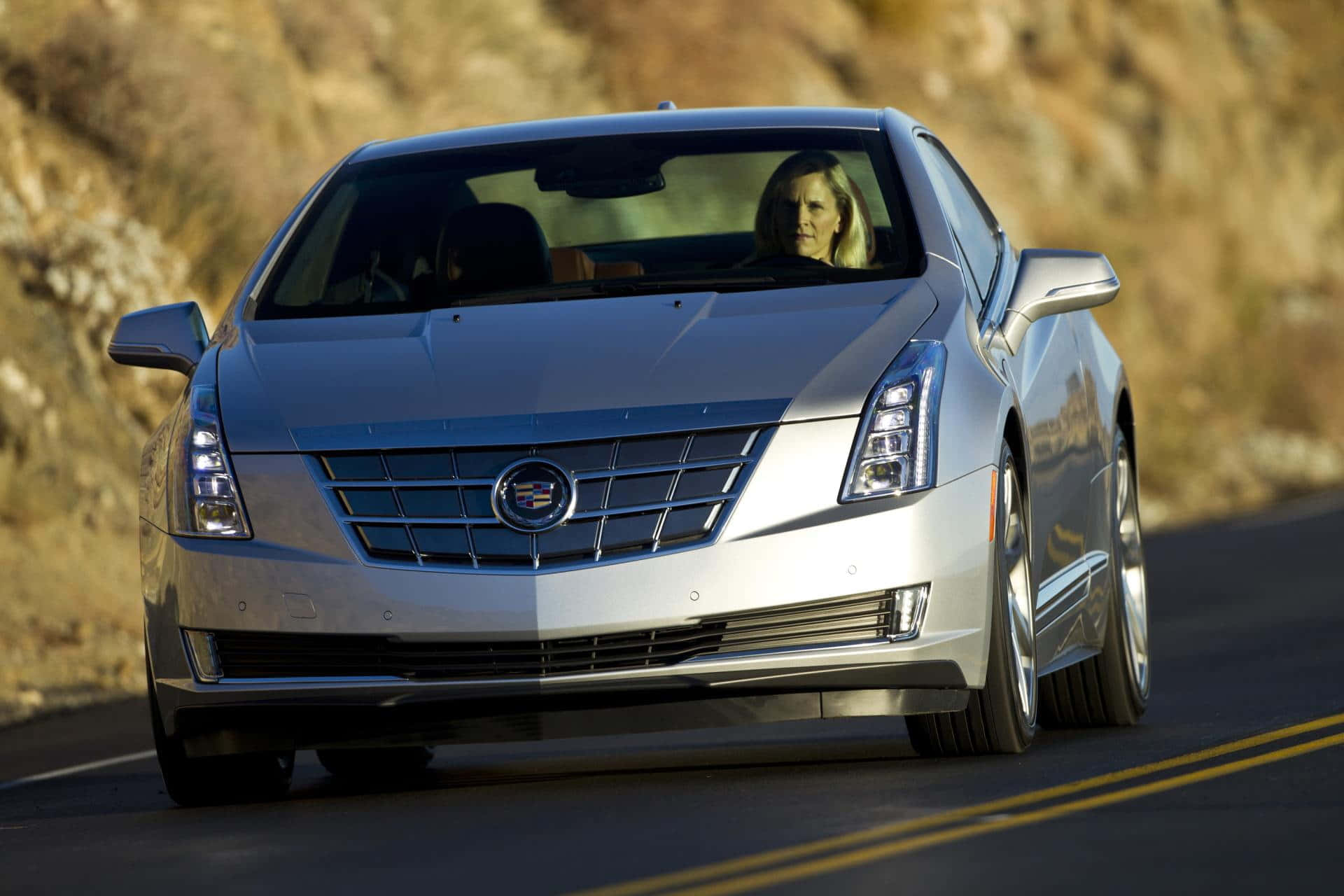 Cadillac Elr 桌布 壁紙 — 一輛銀色Cadillac ELR沿著蜿蜒的山路行駛，車內有一位女駕駛。