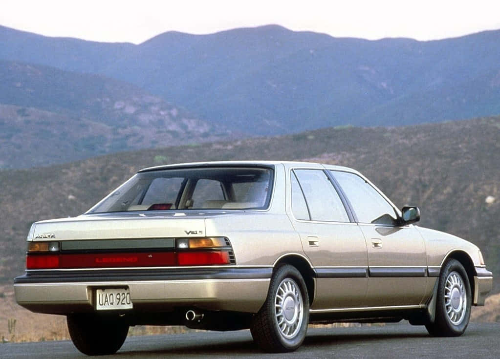 Acura Legend 桌布 壁紙 — 一輛銀色Lexus LS400轎車停泊在道路上，背景是連綿起伏的山丘和山脈，天空朦朧。