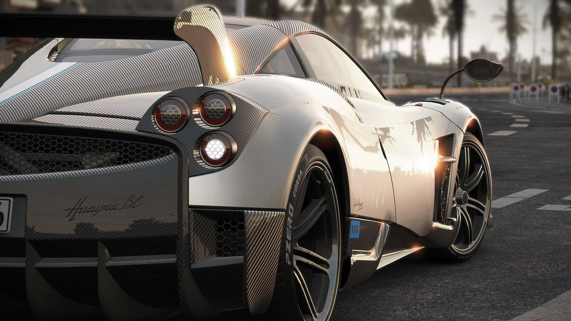 cars 桌布 壁紙 — 一輛銀色Pagani Zonda Cinque跑車在日落時分的賽道上閃閃發光，背景有棕櫚樹。