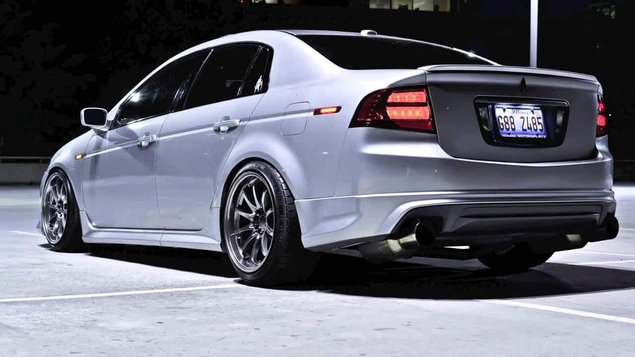 Acura Tsx 桌布 壁紙 — 一輛銀色三菱Lancer Evolution在夜間停放在停車場，帶有發光的紅色尾燈和定制輪圈。