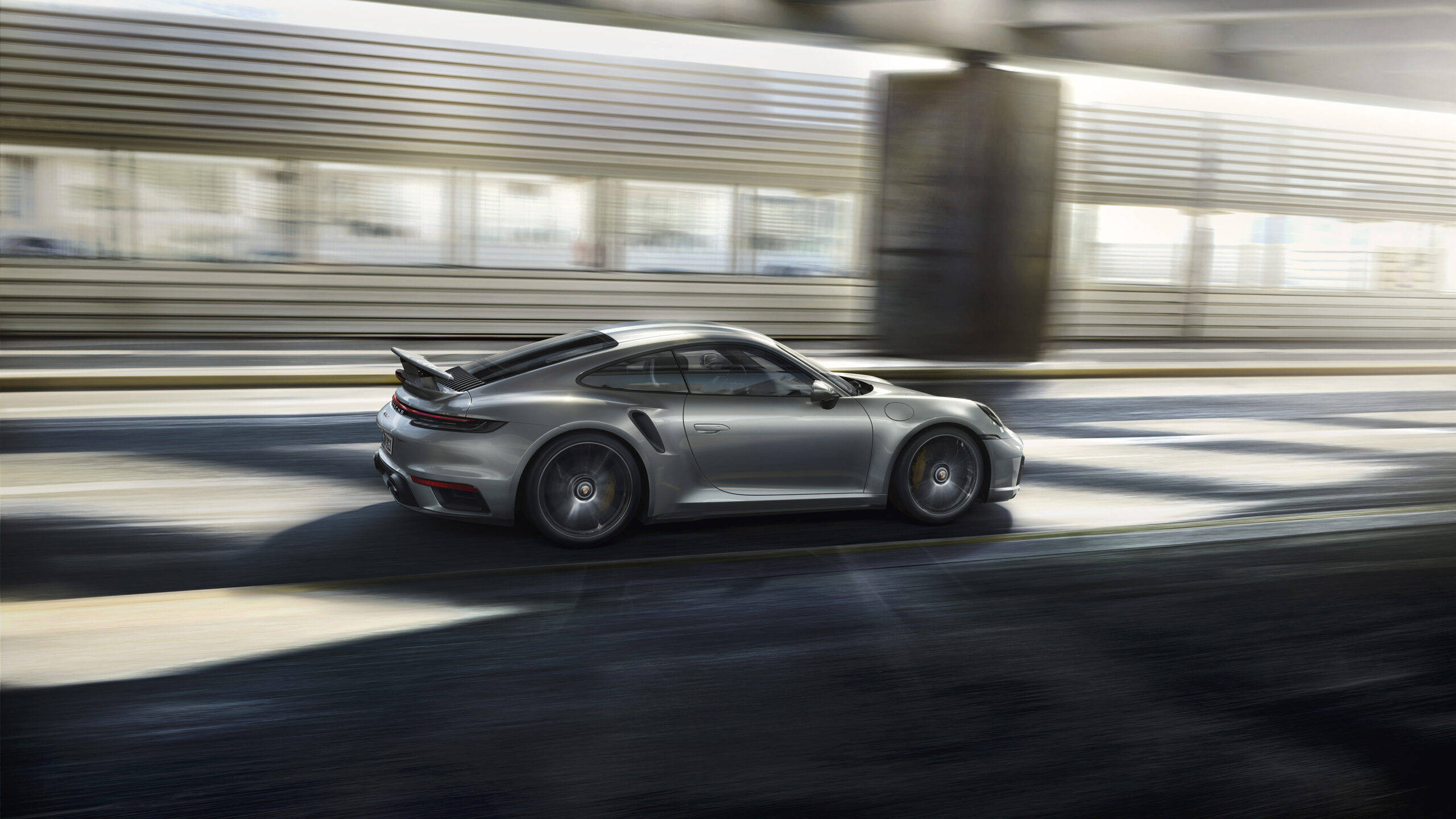 銀色保時捷911 Turbo S在現代都市隧道中疾馳。