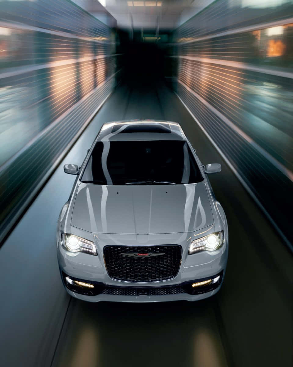 Chrysler 桌布 壁紙 — 一輛銀色克萊斯勒轎車在隧道中飛馳，模糊的燈光掠過其發光的車頭燈。