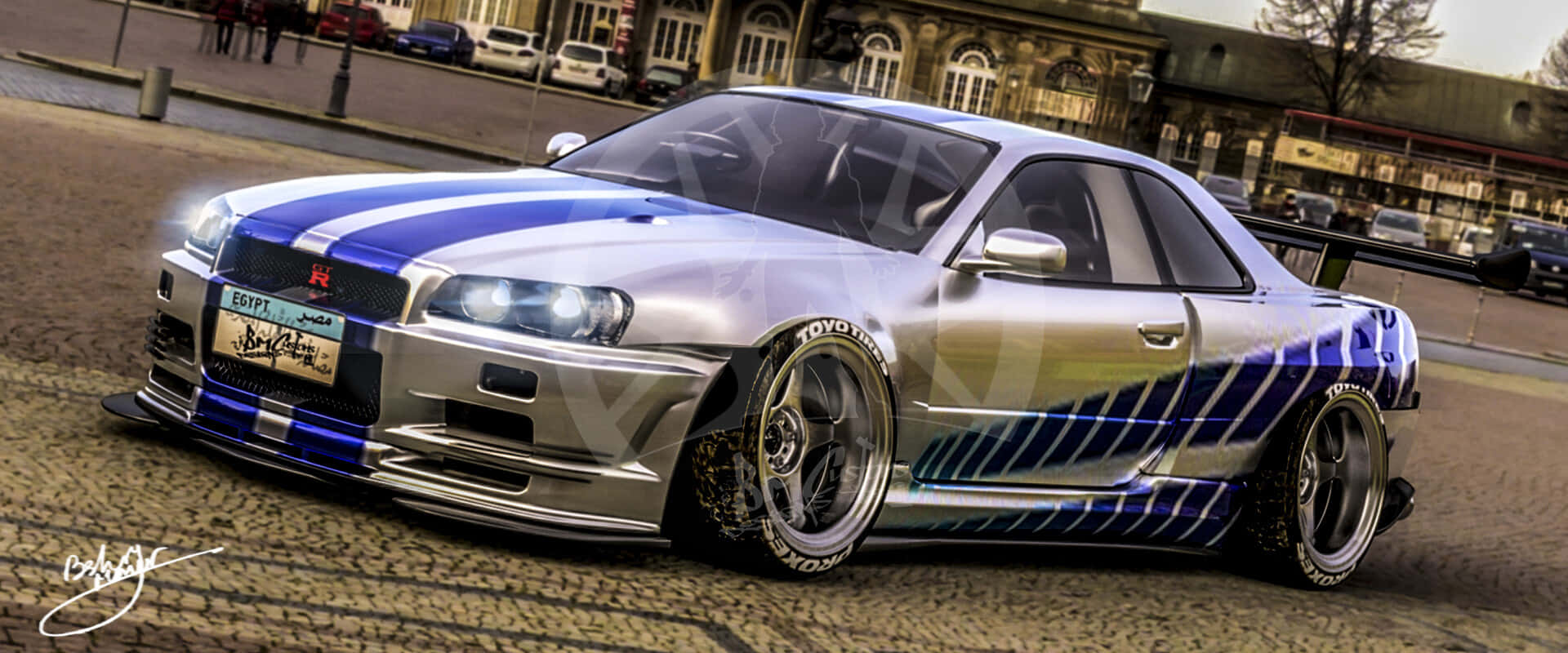 Paul Walker Skyline 桌布 壁紙 — 一輛銀色和藍色的日產Skyline R34漂移車，帶有自訂條紋，停在歐洲風格建築前的鵝卵石街道上。