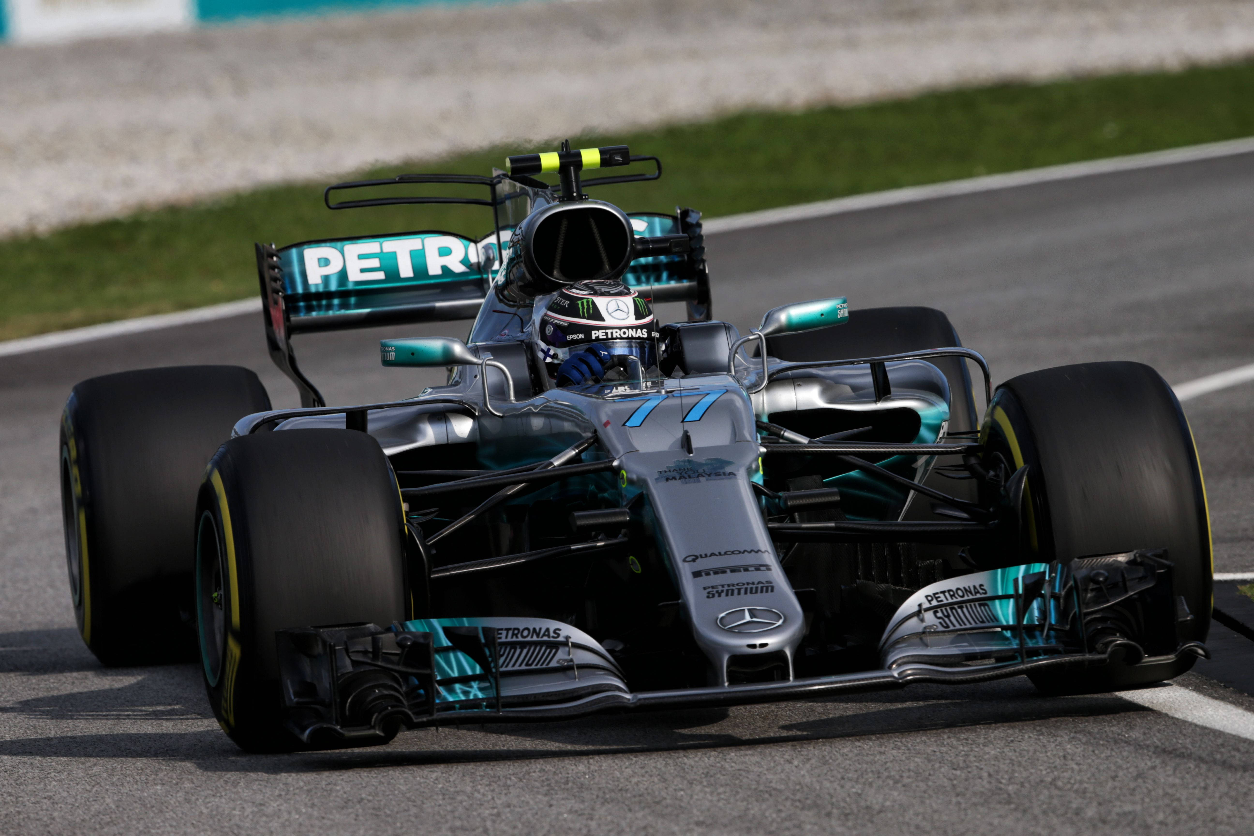 Valtteri Bottas 桌布 壁紙 — 一輛銀色和青綠色的梅賽德斯一級方程式賽車在賽道上疾馳，車手戴著頭盔清晰可見。