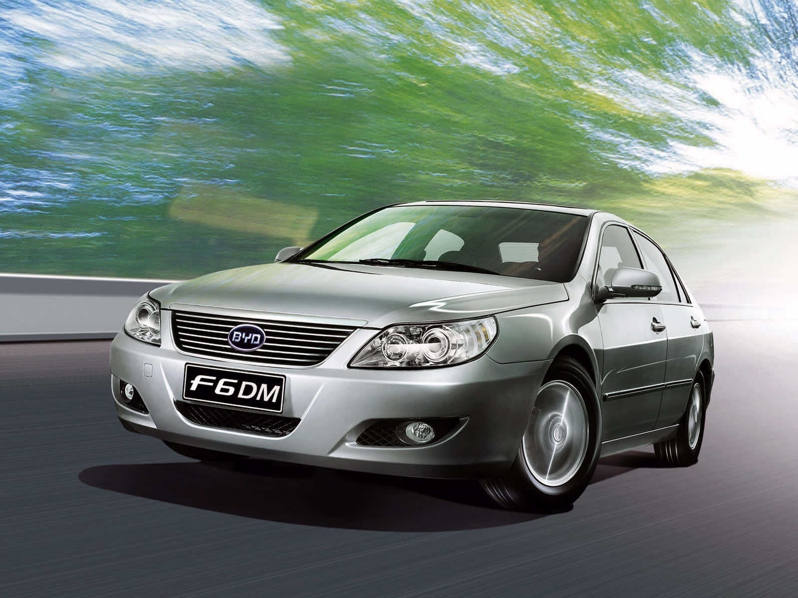 Byd 桌布 壁紙 — 一輛銀色比亞迪F6DM轎車在動態運動鏡頭中向前飛馳，模糊的綠色樹葉掠過。