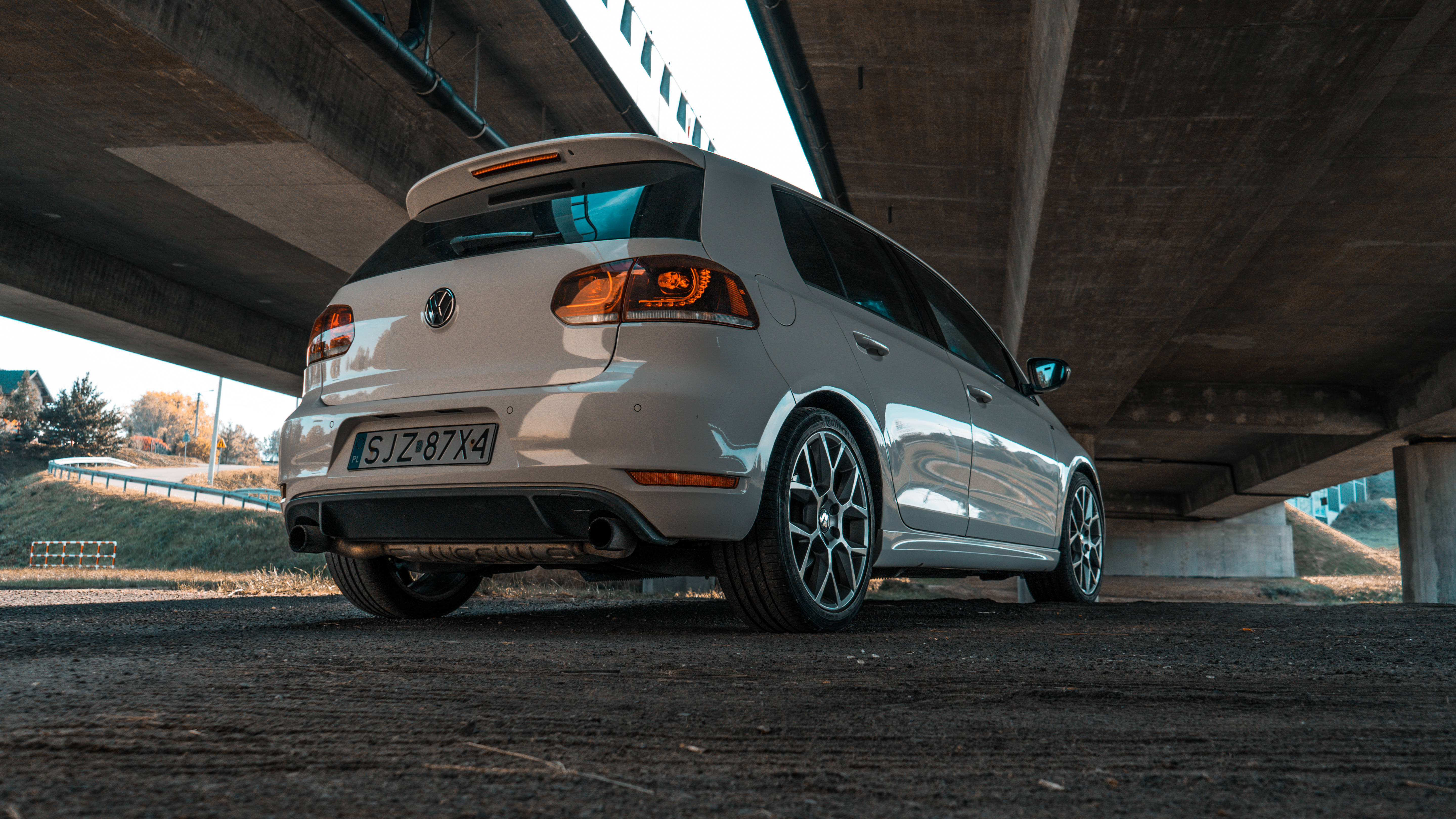 Gti 桌布 壁紙 — 一輛銀色福斯 Golf R 停放在混凝土天橋下，發光的尾燈在其流線型車身上反射。