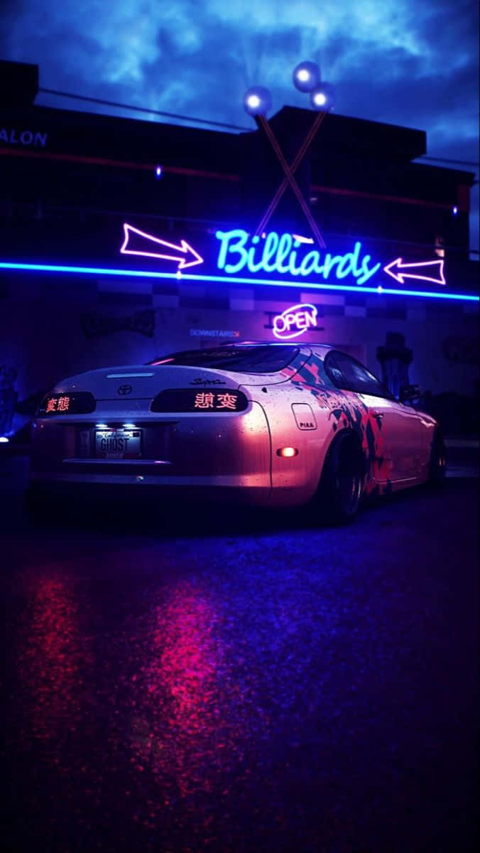 桌布 壁紙 — 一輛銀色跑車在夜間濕滑的街道上，於『Billiards』招牌散發的鮮豔藍色和粉紅色霓虹燈下閃閃發光。
