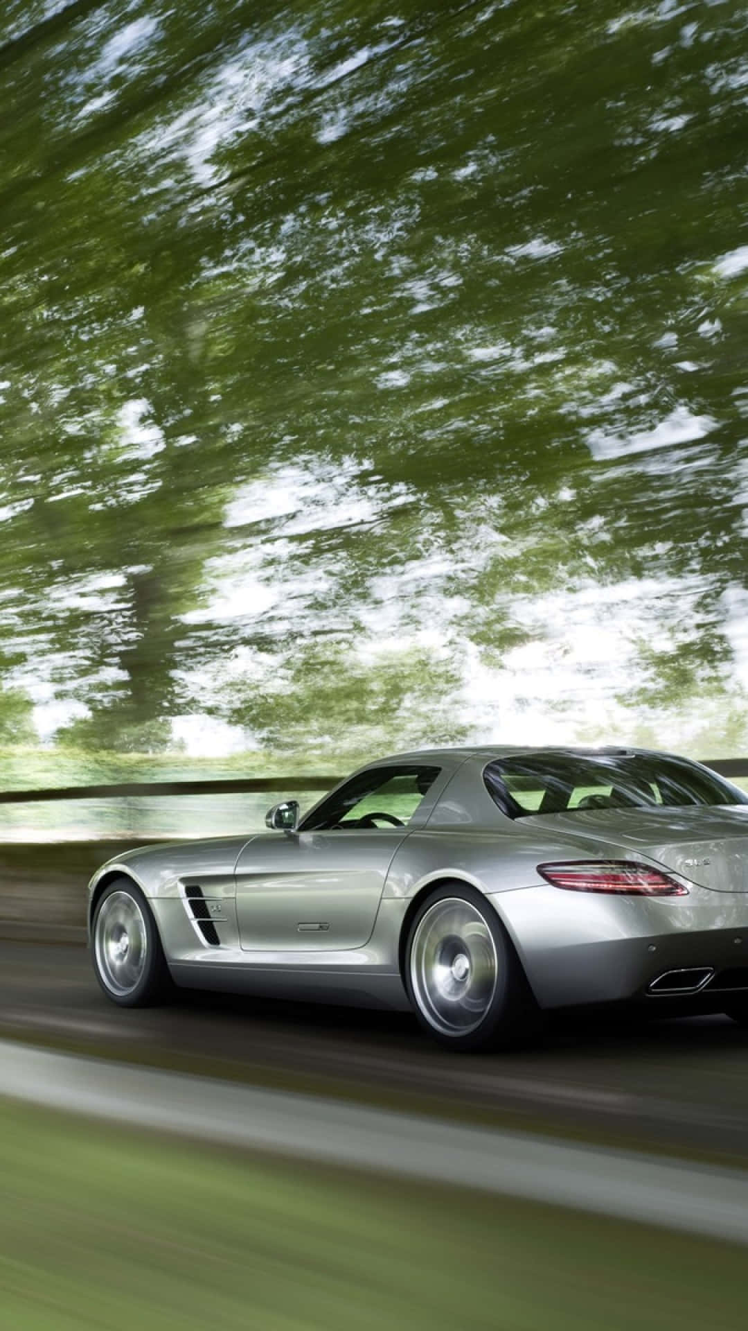 Mercedes 桌布 壁紙 — 一輛銀色跑車在茂密的綠色森林中疾馳，動態模糊強調了速度。
