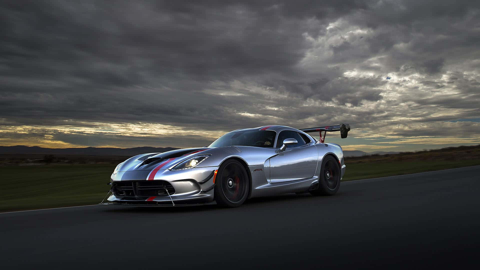Dodge 桌布 壁紙 — 一輛銀色道奇Viper ACR在黃昏時分戲劇性的多雲天空下，在黑暗的道路上奔馳。