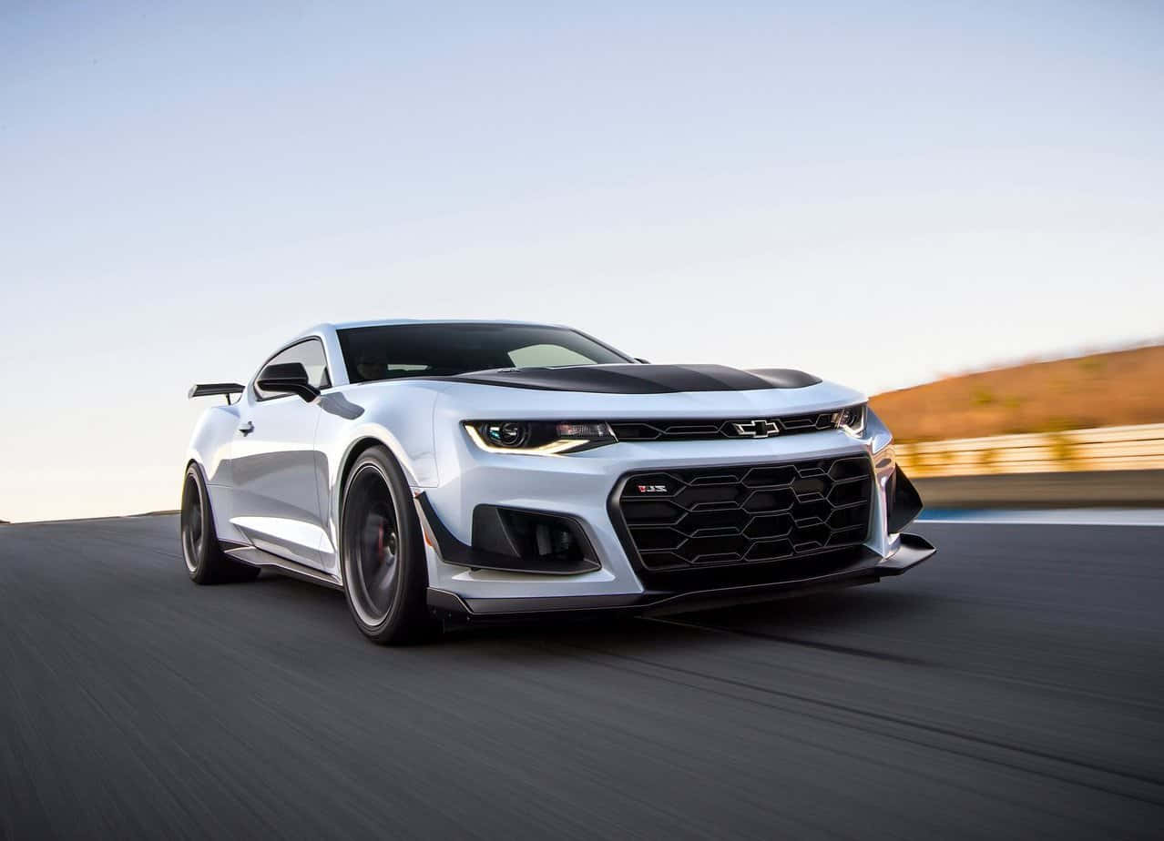 Cool Camaro 桌布 壁紙 — 一輛銀色雪佛蘭Camaro SS在晴朗天空下沿沙漠賽道飛馳，動態模糊凸顯其力量。