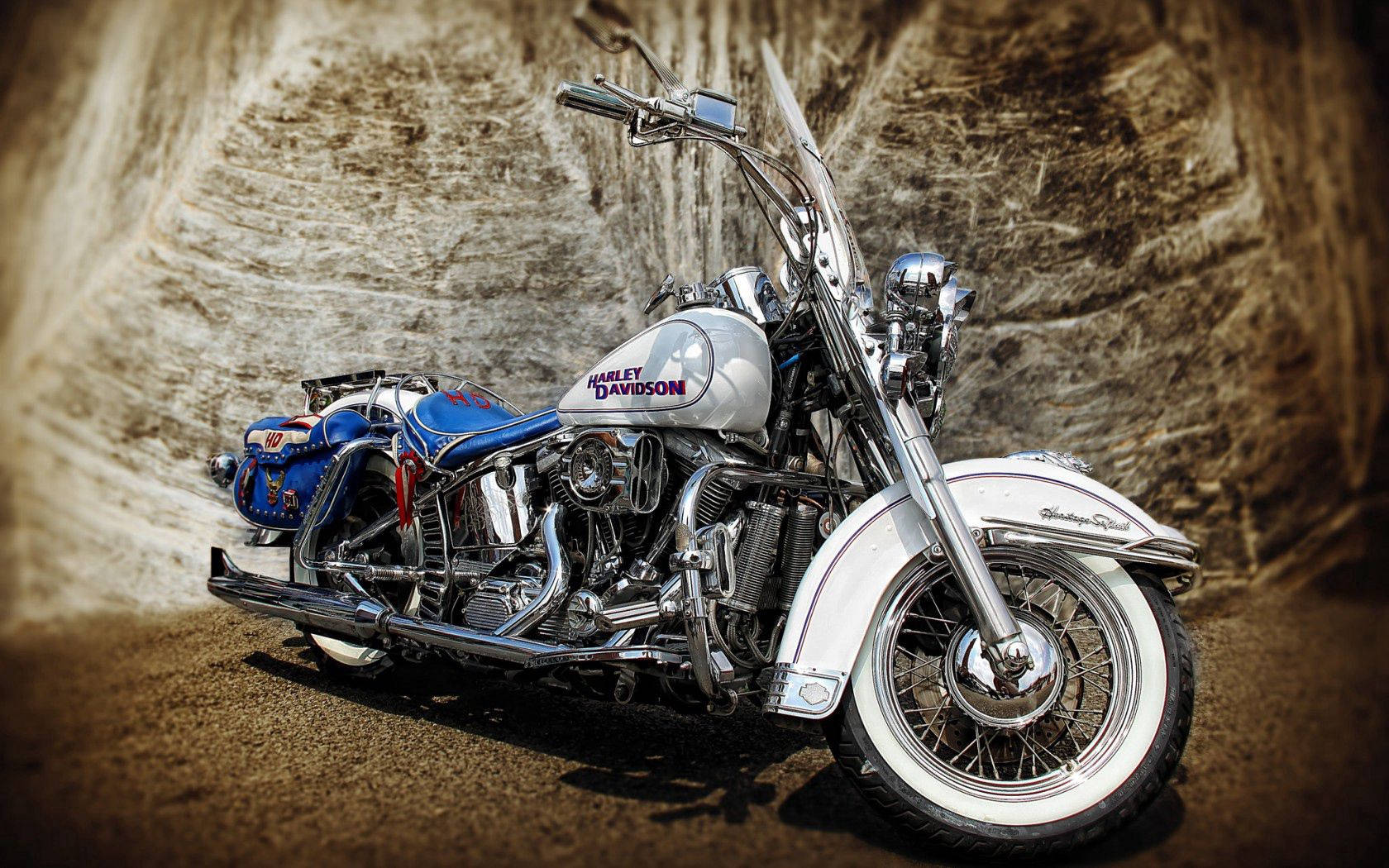 Harley 桌布 壁紙 — 一輛鍍鉻和藍色的Harley-Davidson摩托車在溫暖燈光下，在紋理石隧道牆前閃閃發光。