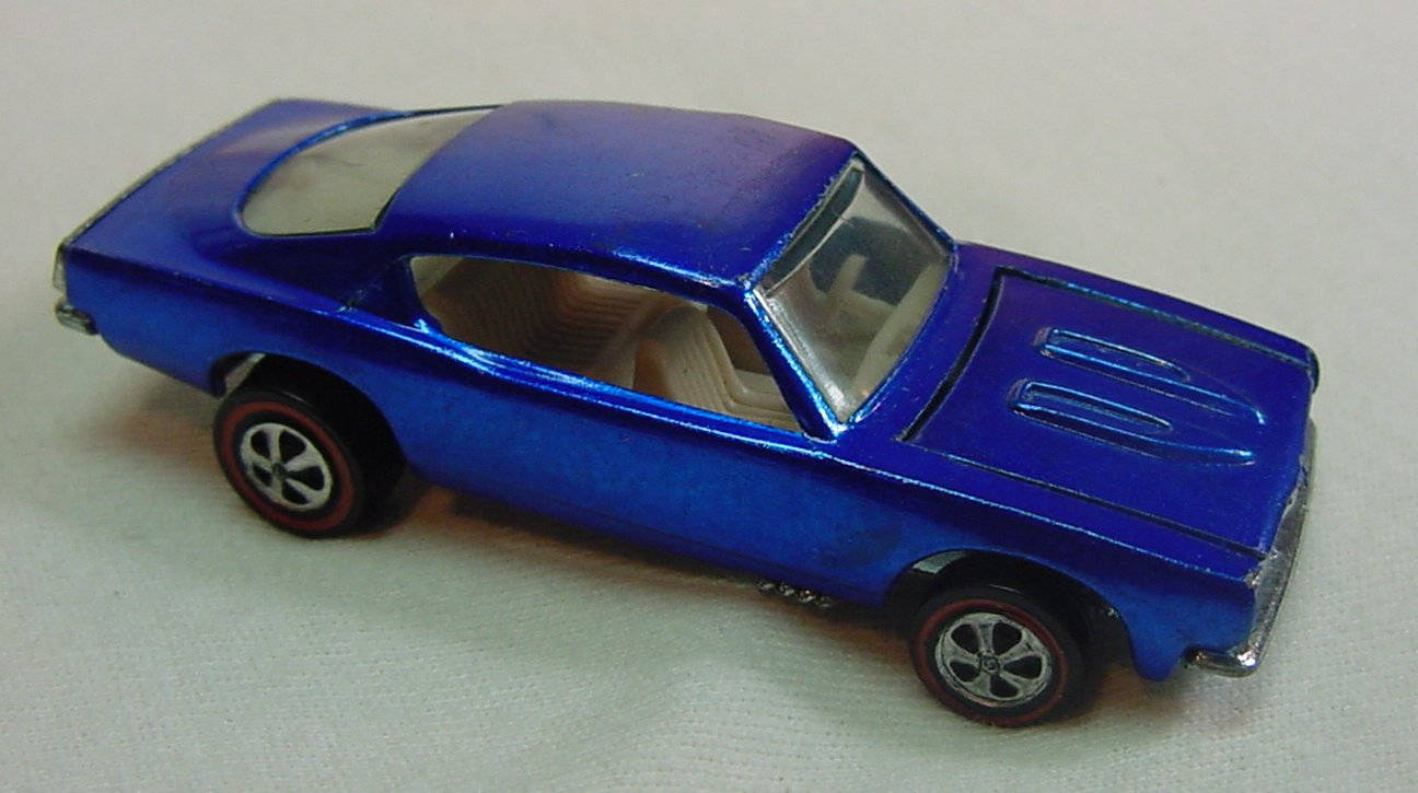 Barracuda 桌布 壁紙 — 一輛閃亮的藍色復古玩具肌肉車，帶有紅色邊緣的輪子，放置在純白色表面上。