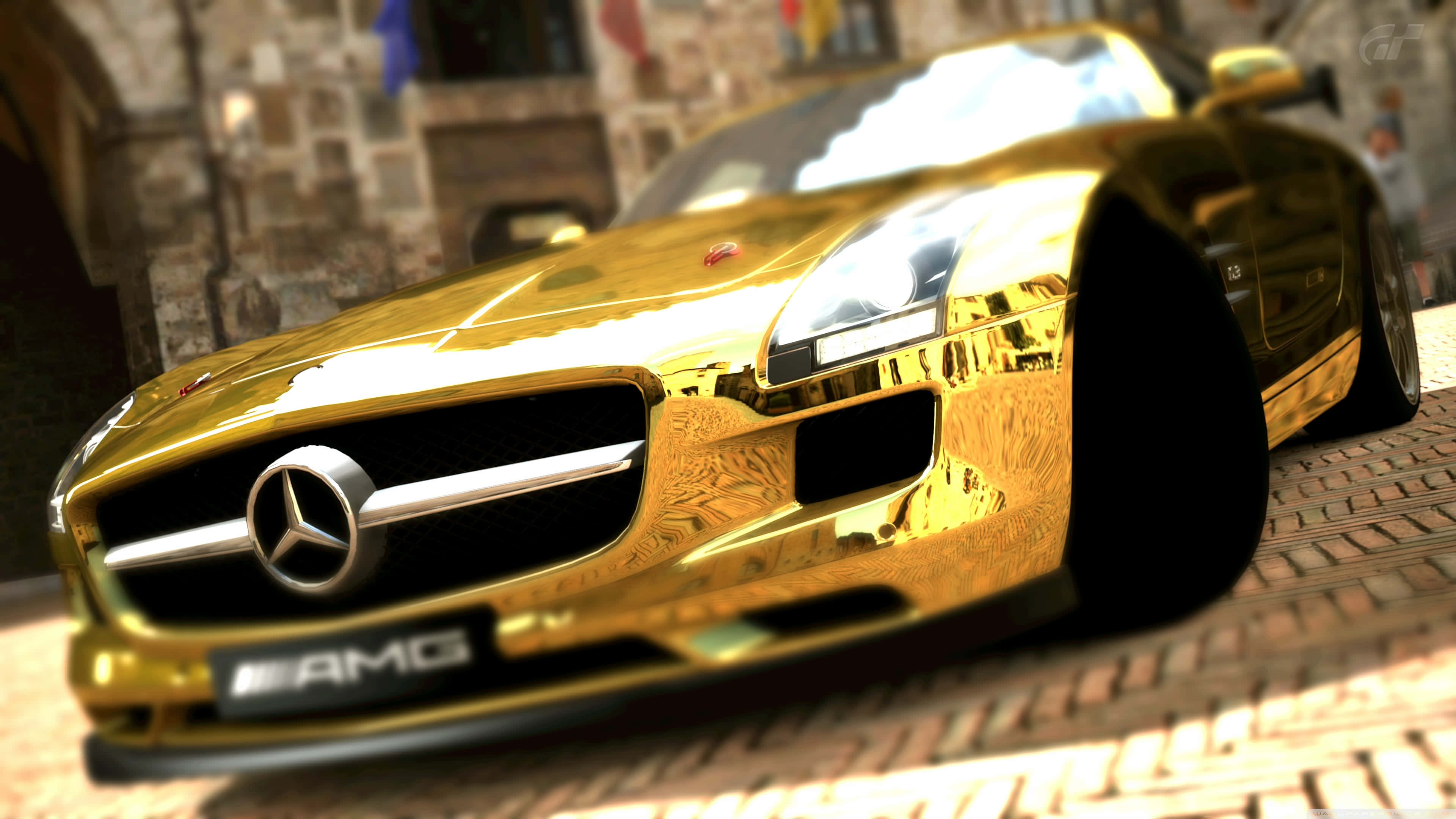 Gold Cars 桌布 壁紙 — 一輛閃亮的金色 Mercedes-AMG 跑車停泊在鵝卵石街道上，背景是歷史悠久的石建築。