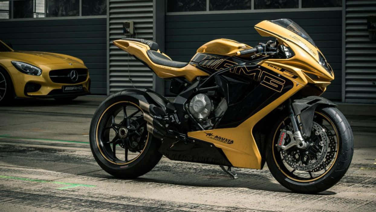  壁紙 — 一輛閃亮的金色和黑色AGUSTA機車帶有AMG品牌，停在一輛匹配的黃色Mercedes-AMG GT旁邊，在現代車庫中。