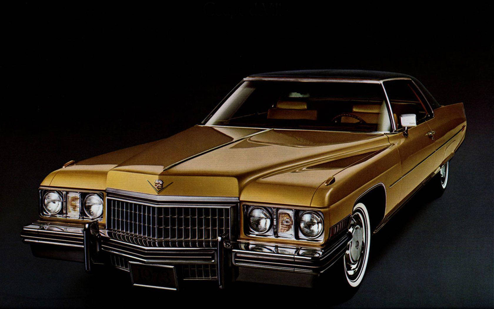 Cadillac 桌布 壁紙 — 一輛閃亮的金色經典凱迪拉克轎車，帶有鍍鉻飾邊和白牆輪胎，在黑色攝影棚背景下擺拍。