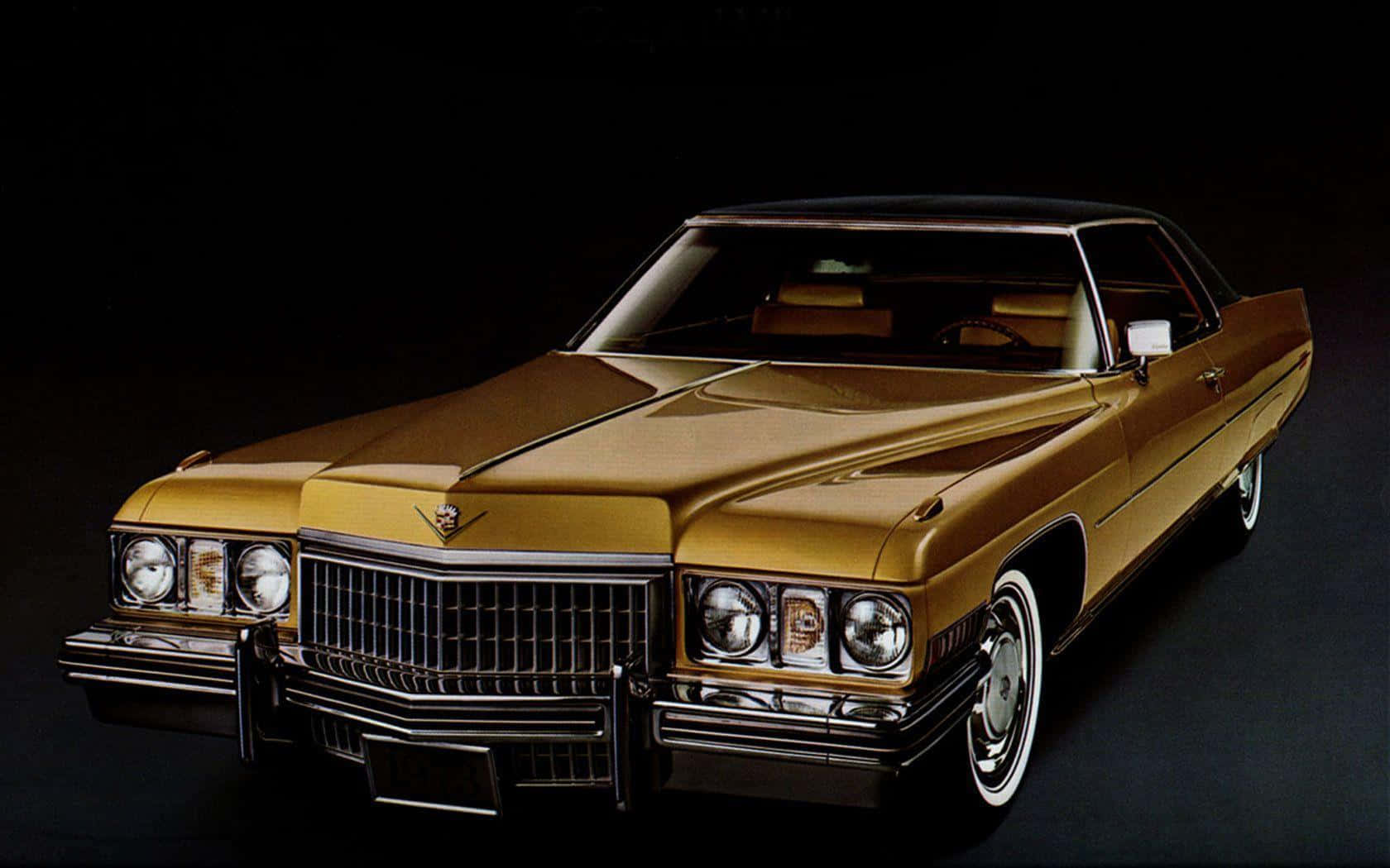 Cadillac 桌布 壁紙 — 一輛閃亮的金色經典凱迪拉克雙門轎車，帶有鍍鉻細節和白色輪胎，以黑色背景為襯托。