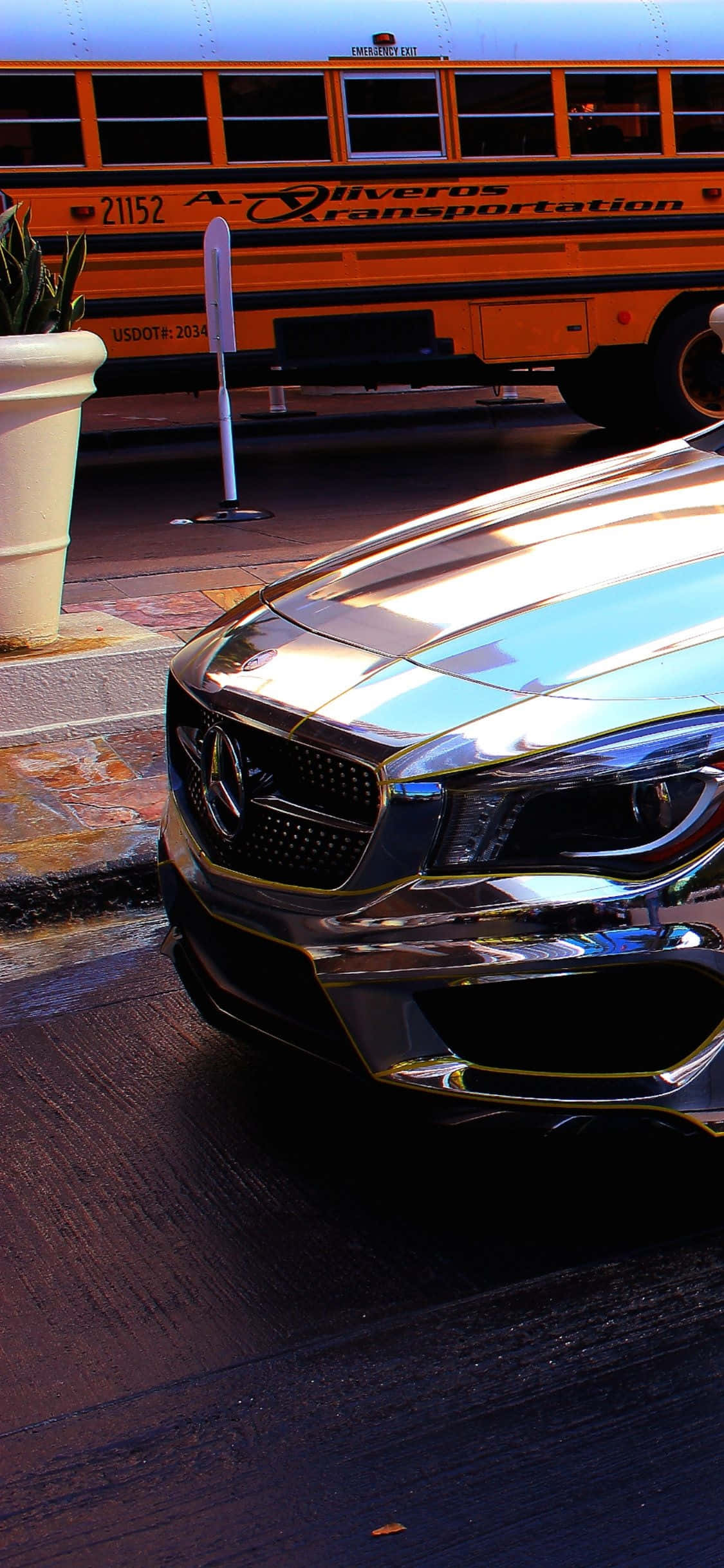 Mercedes 桌布 壁紙 — 一輛閃亮的鍍鉻梅賽德斯跑車在溫暖的金色光線下停在一輛橙色校車旁邊。