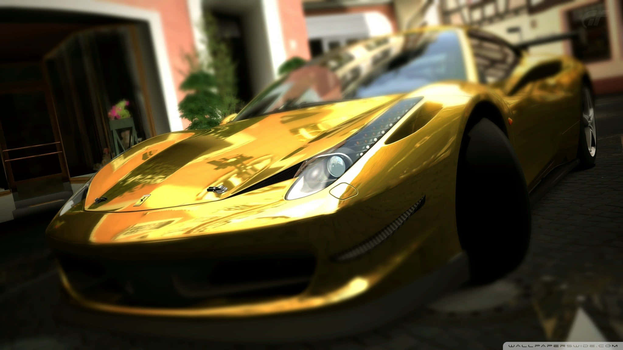 Gold Cars 桌布 壁紙 — 一輛閃閃發光的金色法拉利跑車停放在陽光普照的鵝卵石街道上，背景是模糊的建築物。
