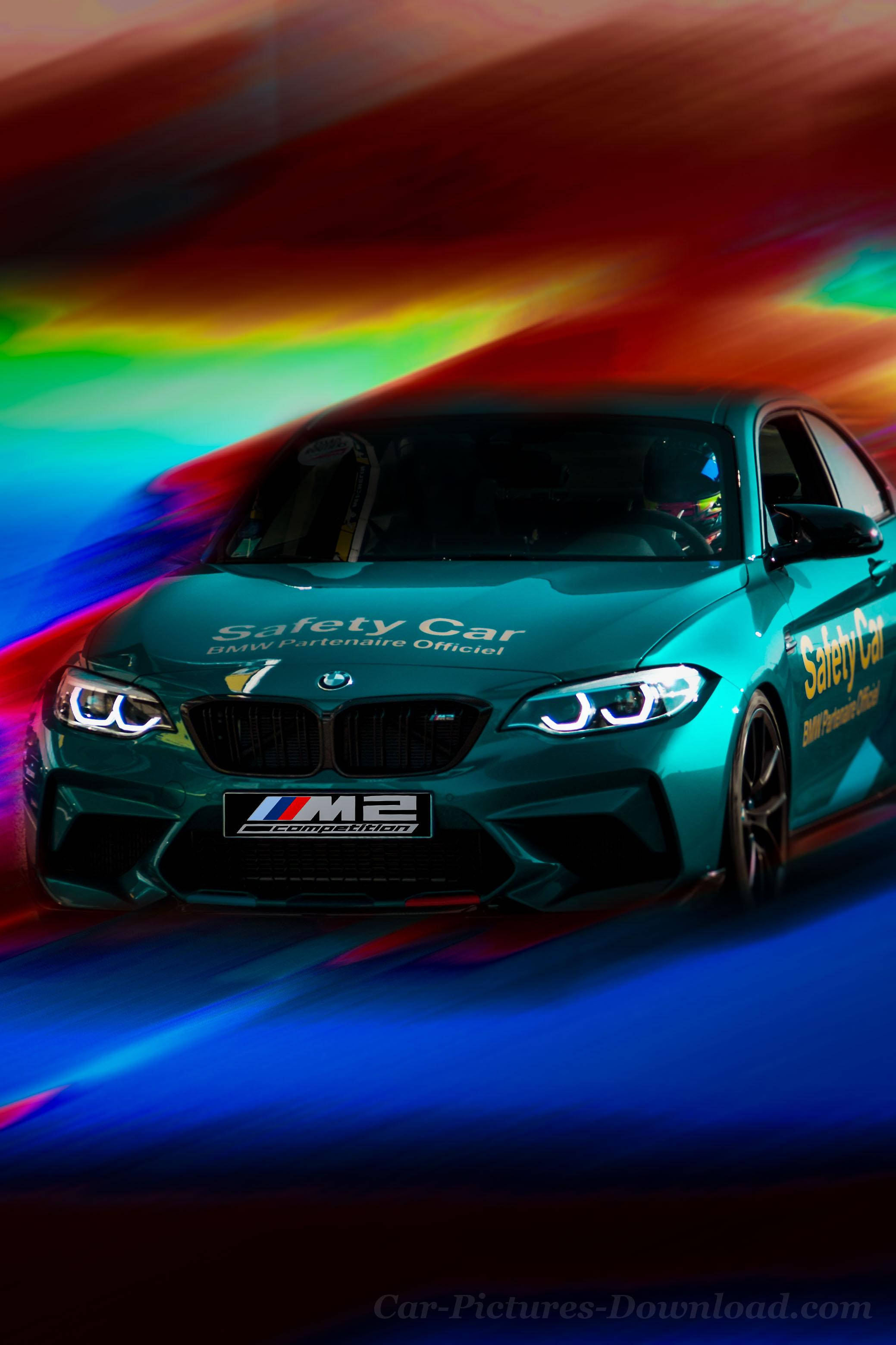 彩色動圖 桌布 壁紙 — 一輛青綠色的BMW M2安全車向前飛馳，身後留下充滿活力的彩虹動態模糊條紋。