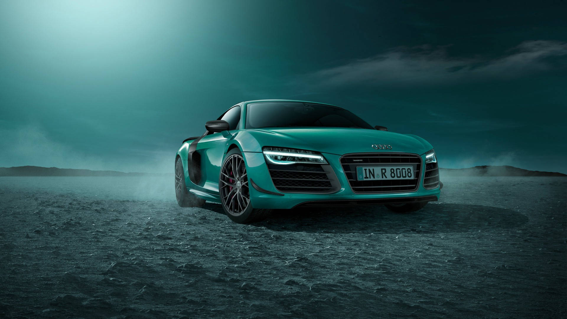 cars 桌布 壁紙 — 一輛青綠色的奧迪R8跑車在霧氣瀰漫的荒涼景觀中疾馳，天空呈現憂鬱的青綠色。