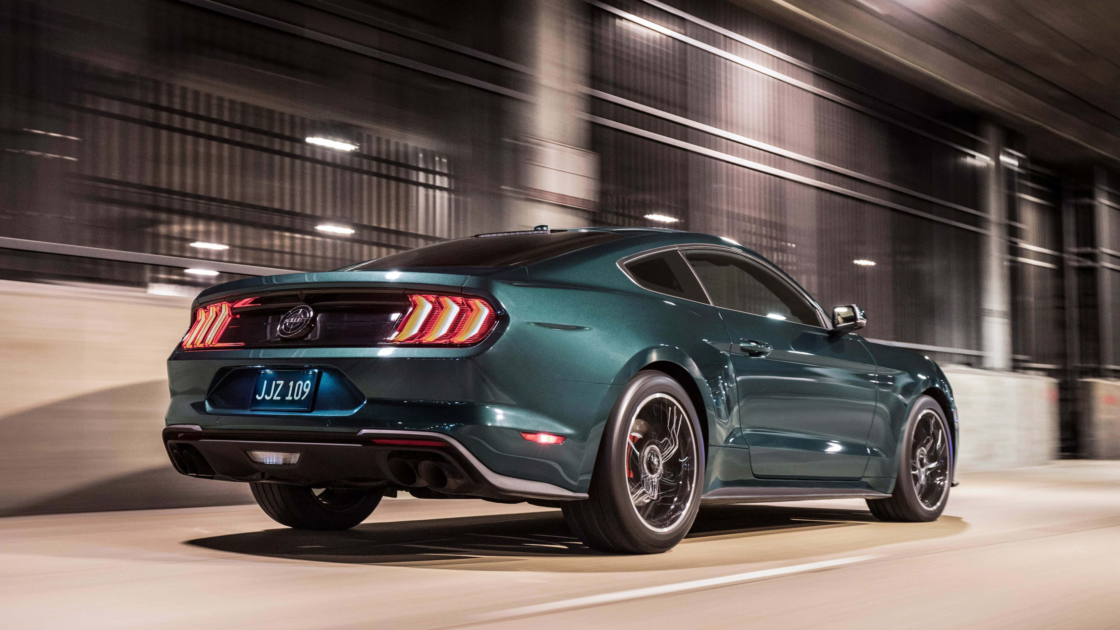 Ford Mustang Bullitt 桌布 壁紙 — 一輛青綠色的福特野馬在都市隧道中疾馳，伴隨著模糊的燈光和動態條紋。