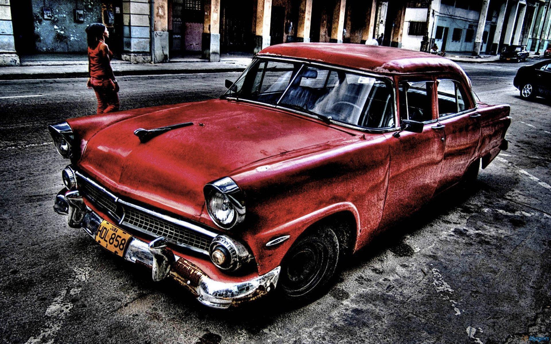 Cadillac 桌布 壁紙 — 一輛風化的紅色復古車停在佈滿沙礫的城市街道上，附近站著一個穿紅色衣服的人。