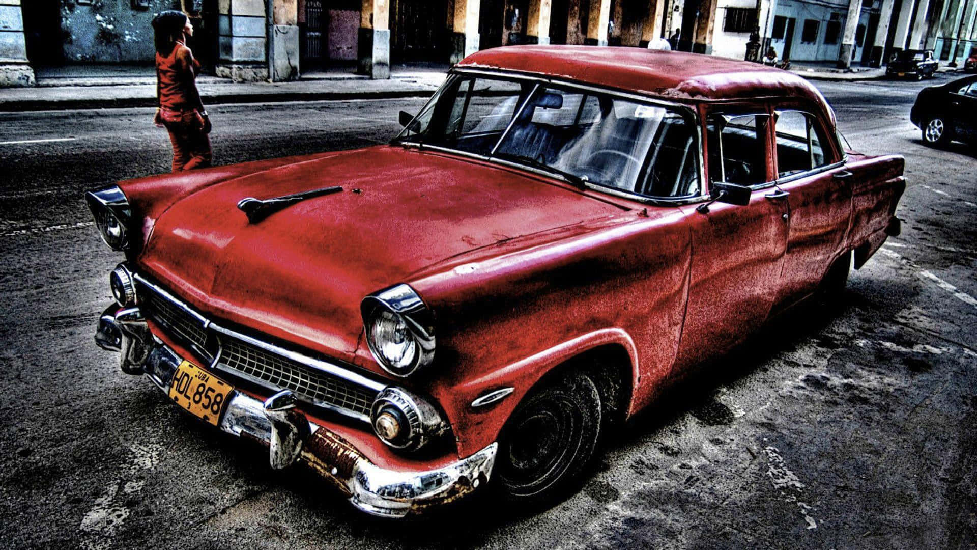 Cadillac 桌布 壁紙 — 一輛風化的紅色復古車停在粗糙的城市街道上，附近有一個人走過。