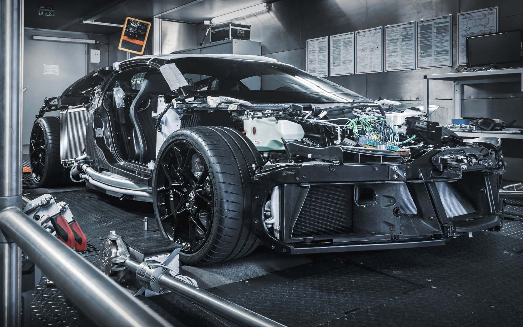 布加迪 桌布 壁紙 — 一輛高性能跑車正在時尚的工業車間中建造，帶有裸露的電線和工具。