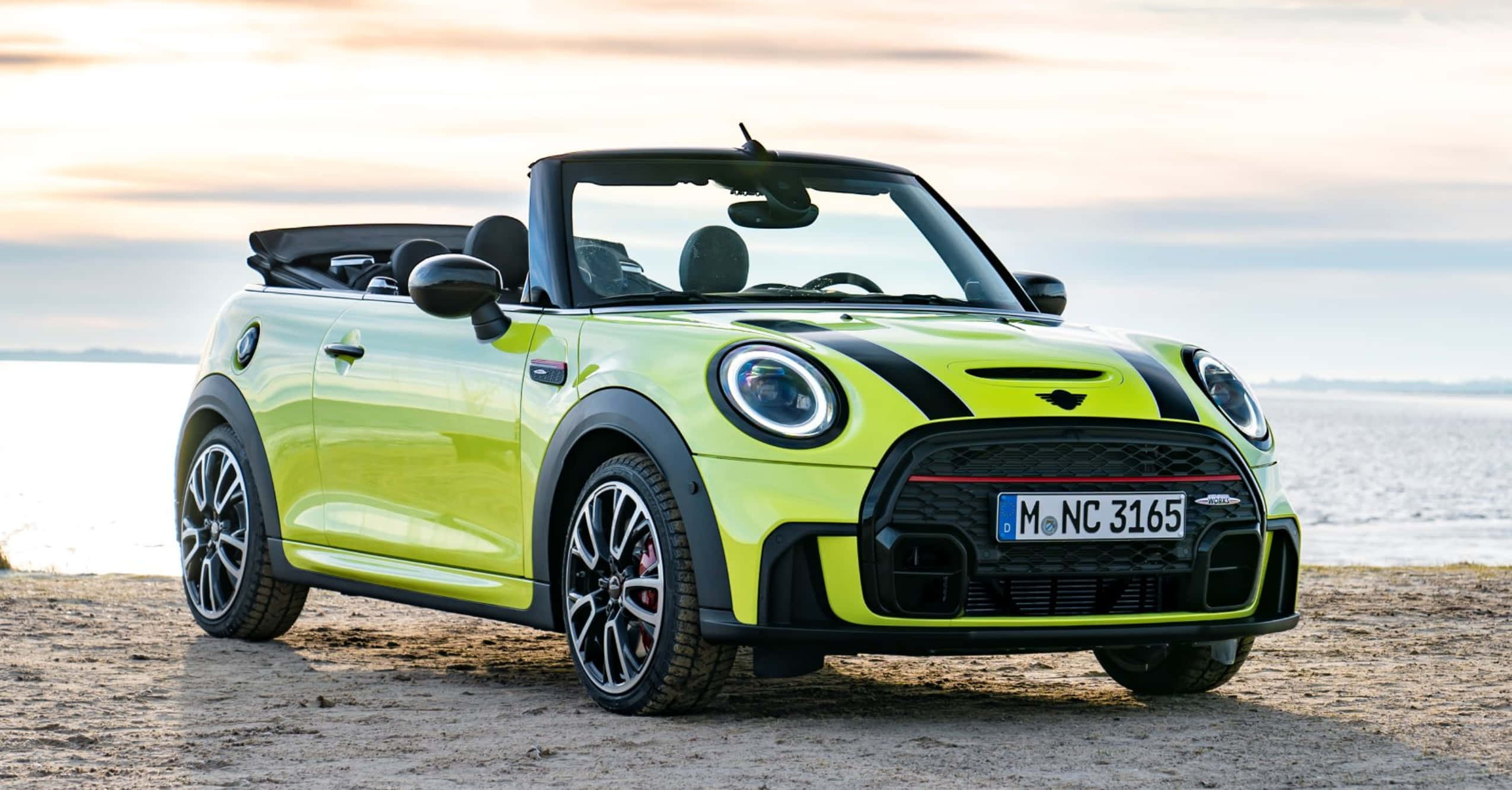 Mini Cooper Convertible 桌布 壁紙 — 一輛鮮亮的萊姆綠色MINI敞篷車停泊在日落時分的沙灘上，背景有海浪。