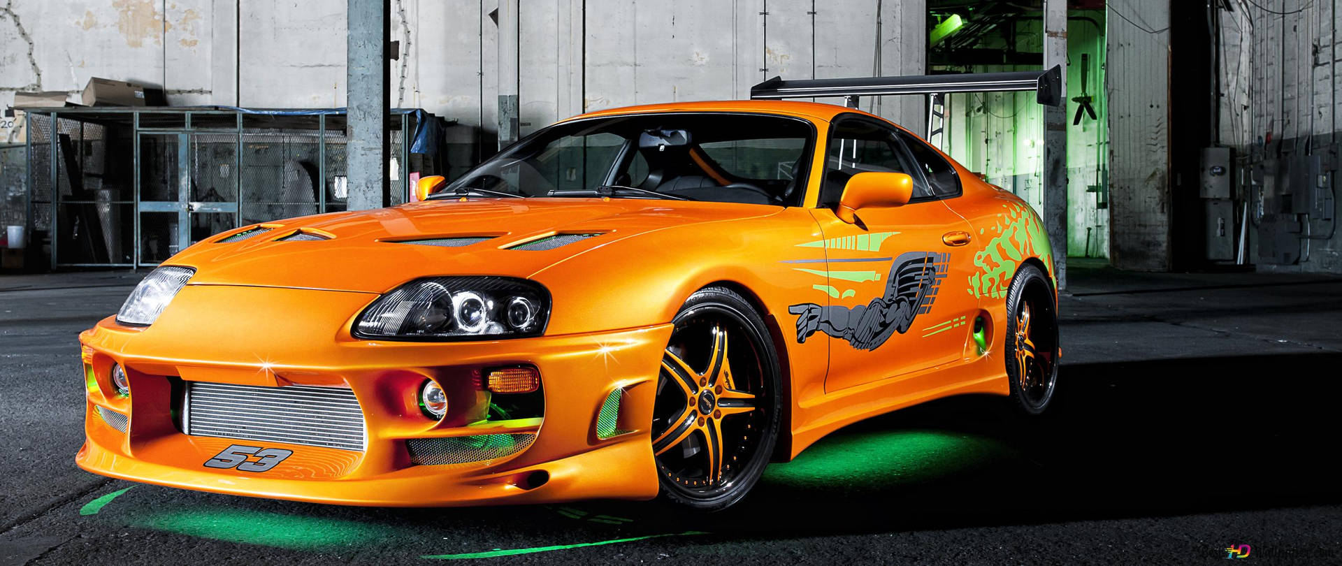 工業車庫中帶綠色底盤燈的橙色改裝跑車。